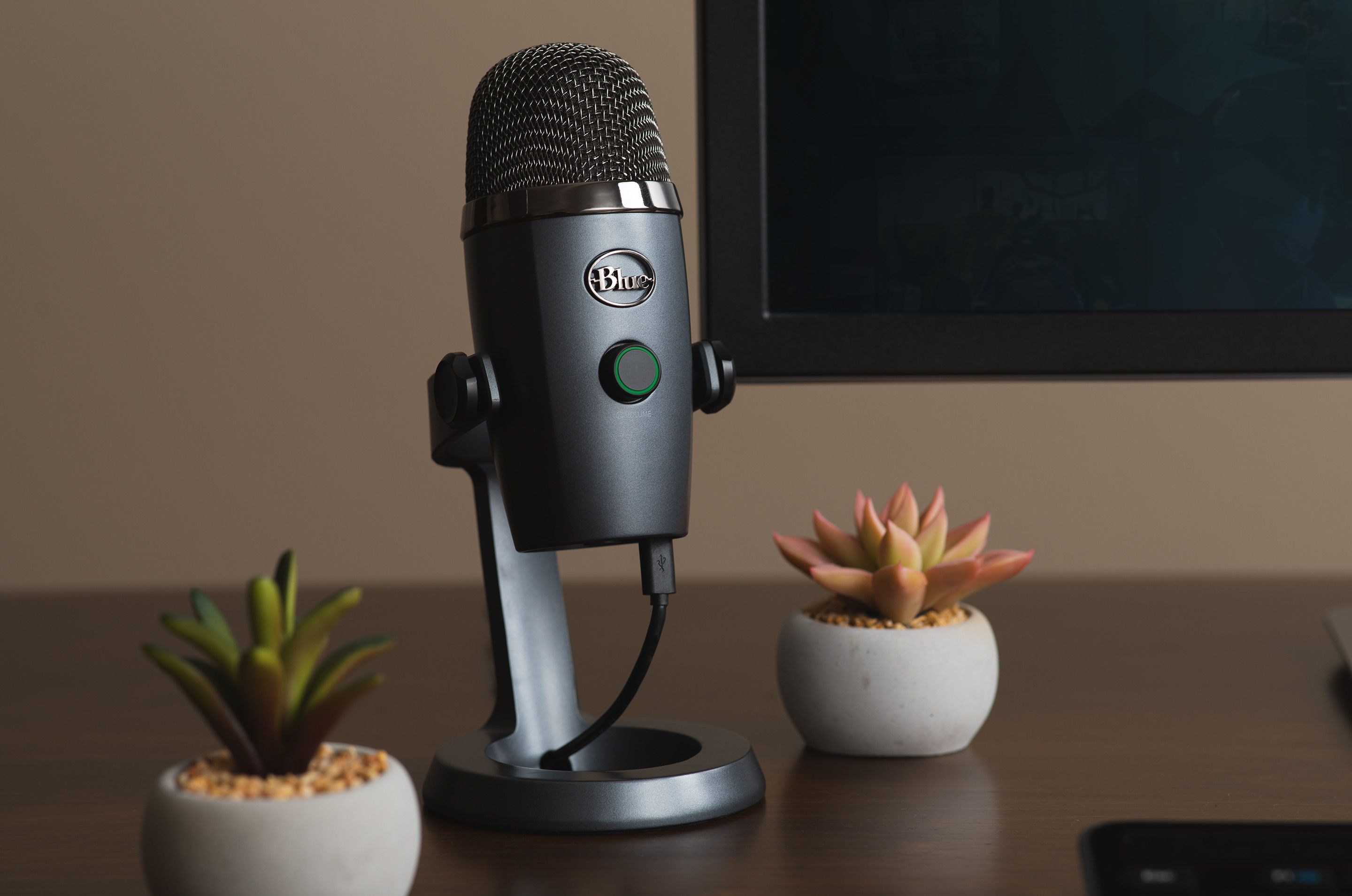metallic gray blue yeti nano microphone on desk turned on