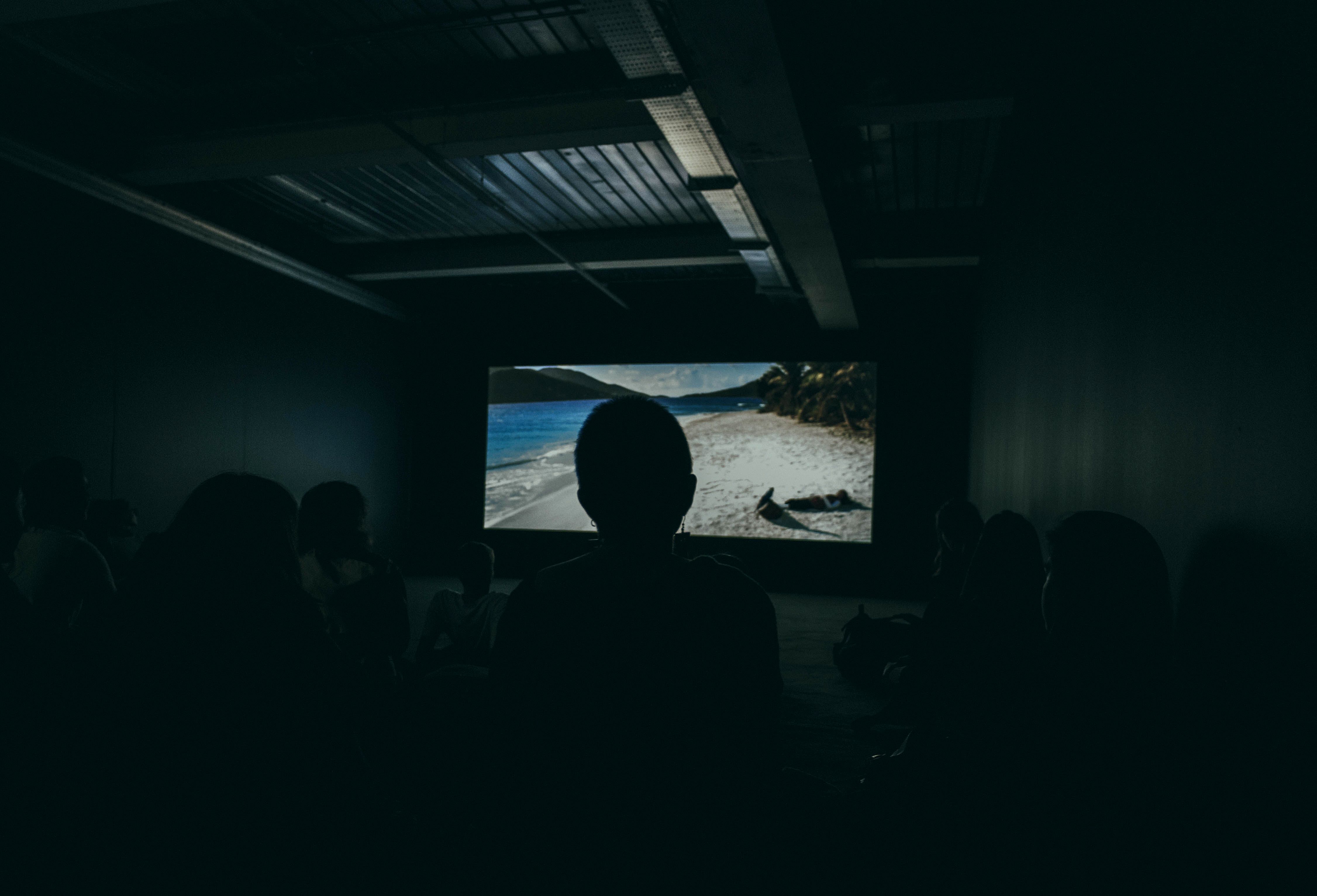A person watching a movie with a smart projector.