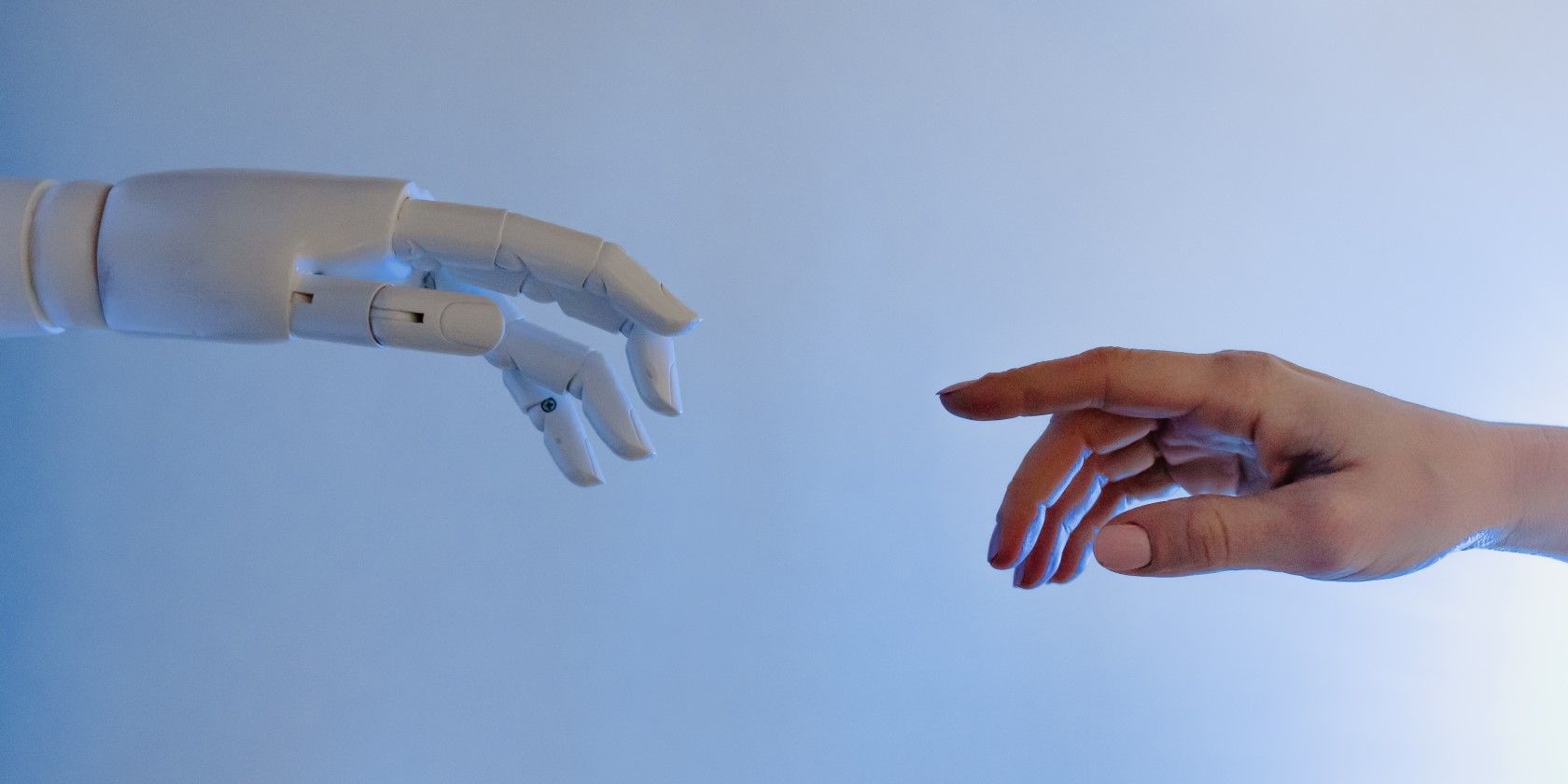 A robot hand is reaching towards a human hand 