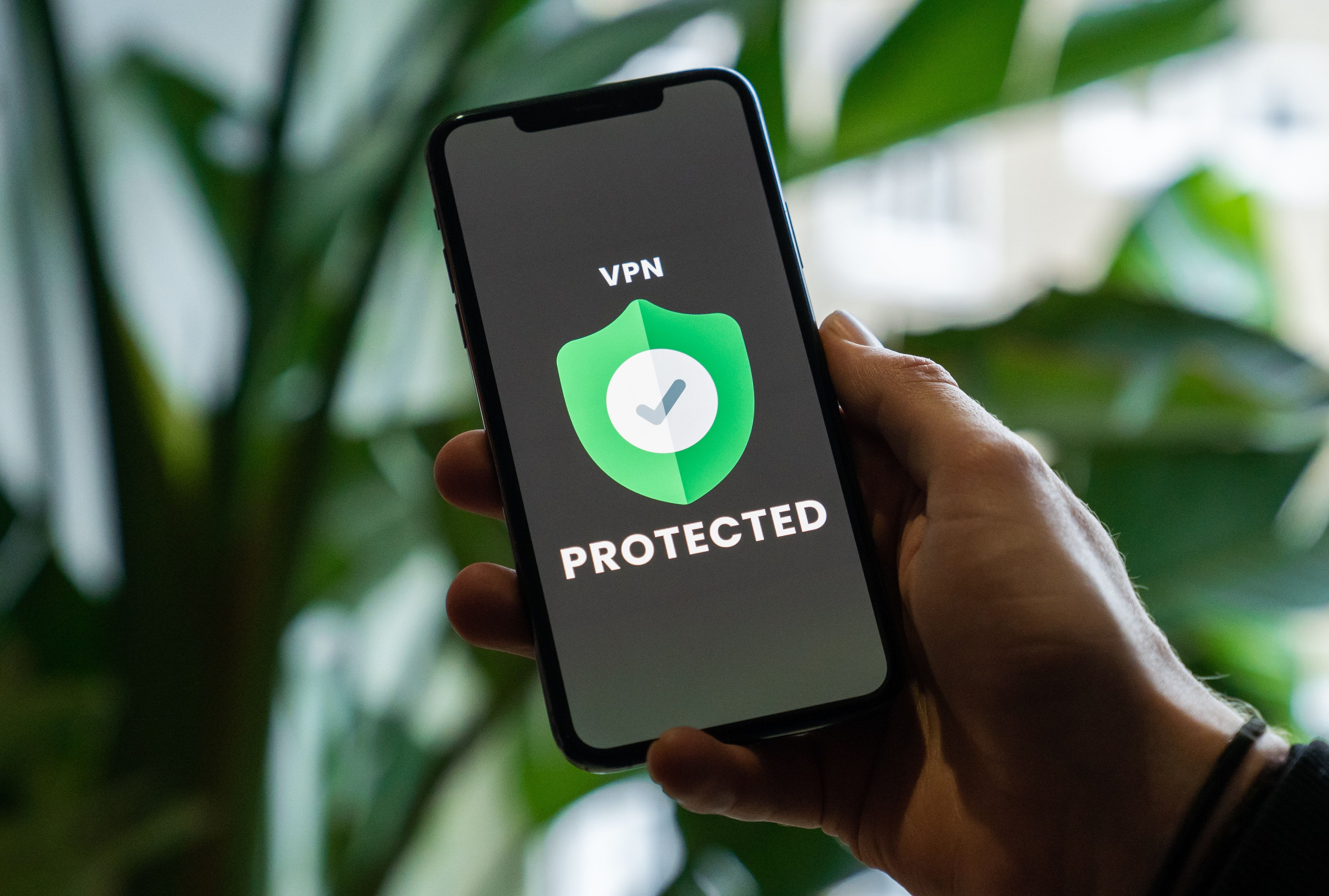 Man Holding Phone that says VPN Protected