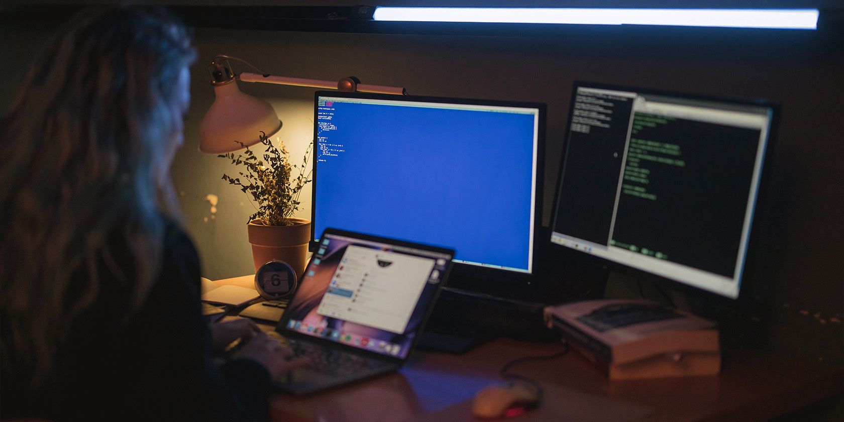 programmer with mutliple screens and a laptop