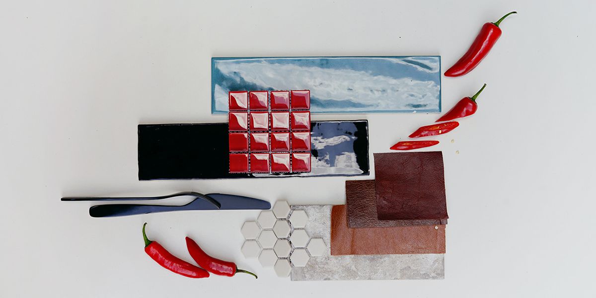 Birdseye view of mood board including red chillies, brown swatches, and black and cream aspects.