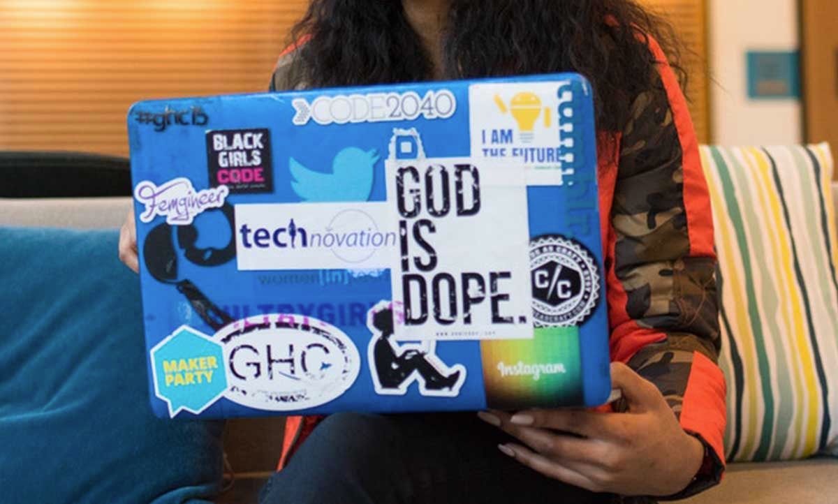 MacBook with a snap on case that has many stickers