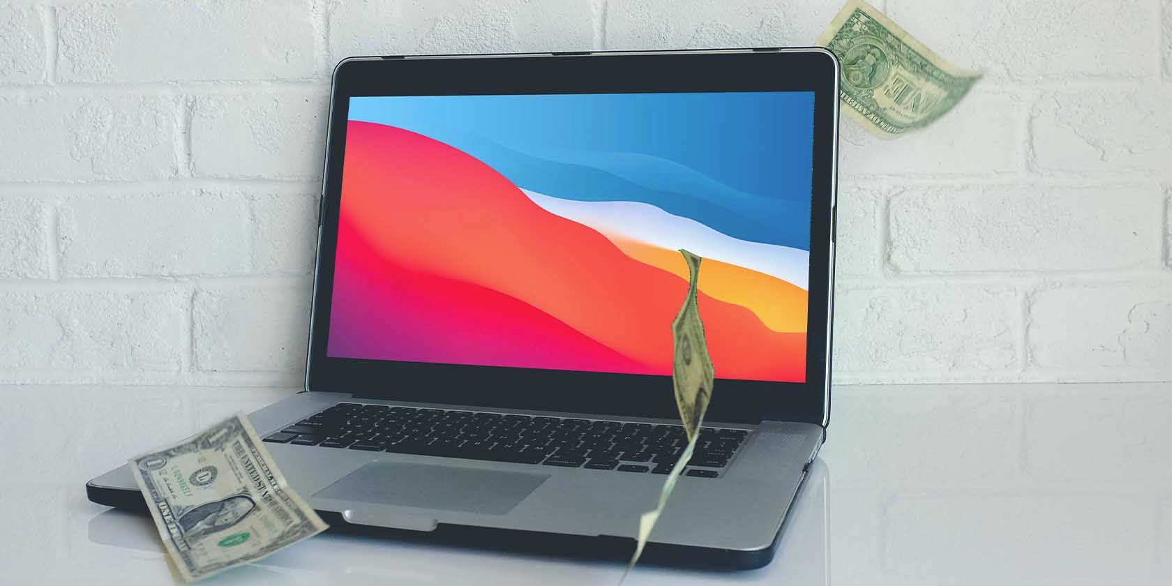 MacBook with Money falling on it