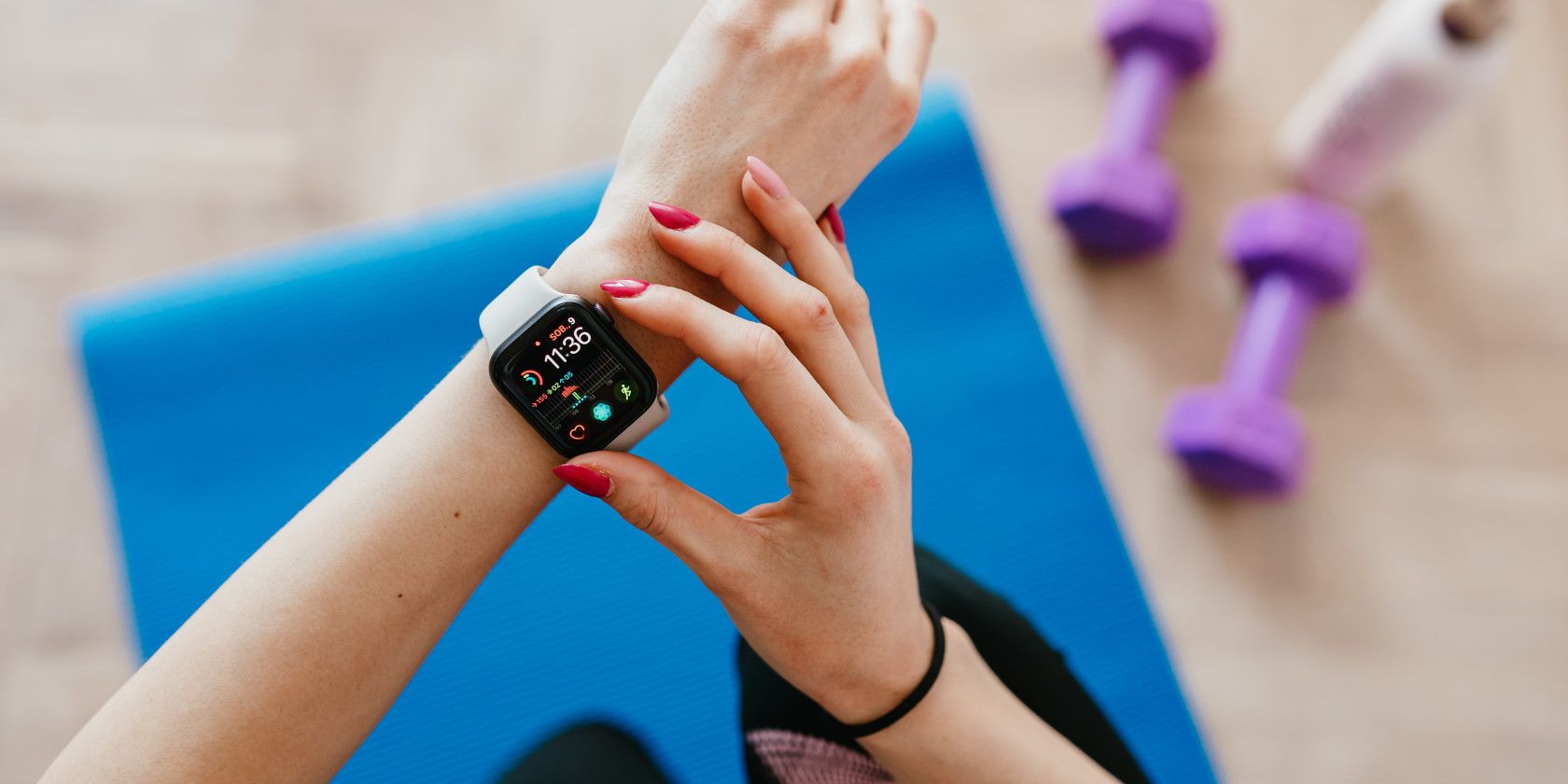 Woman checking smart watch fitness tracker wearable while exercising