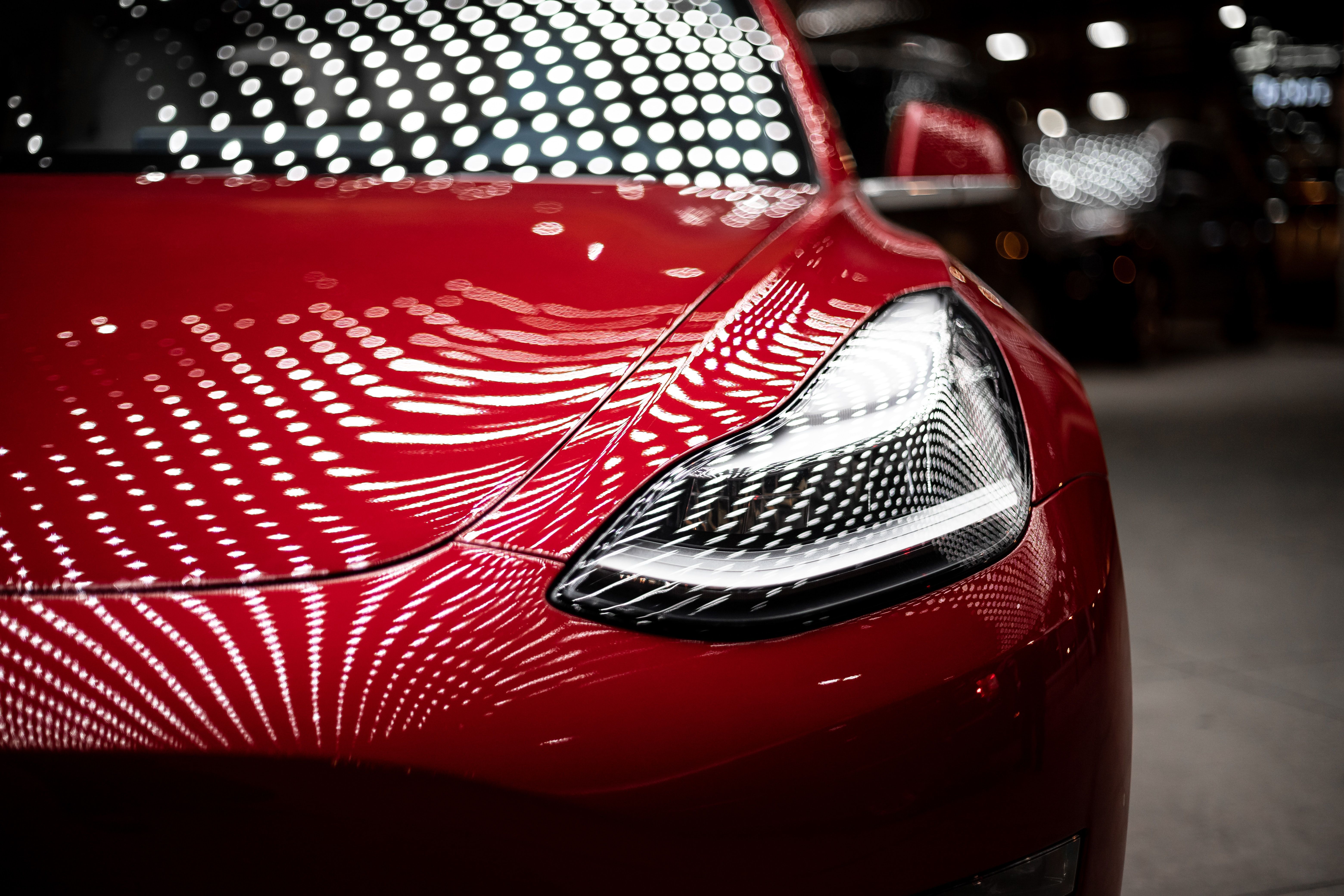 A Tesla Model 3 in red.