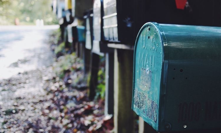 upclose of  a row of mailboxes with a teal one in the front