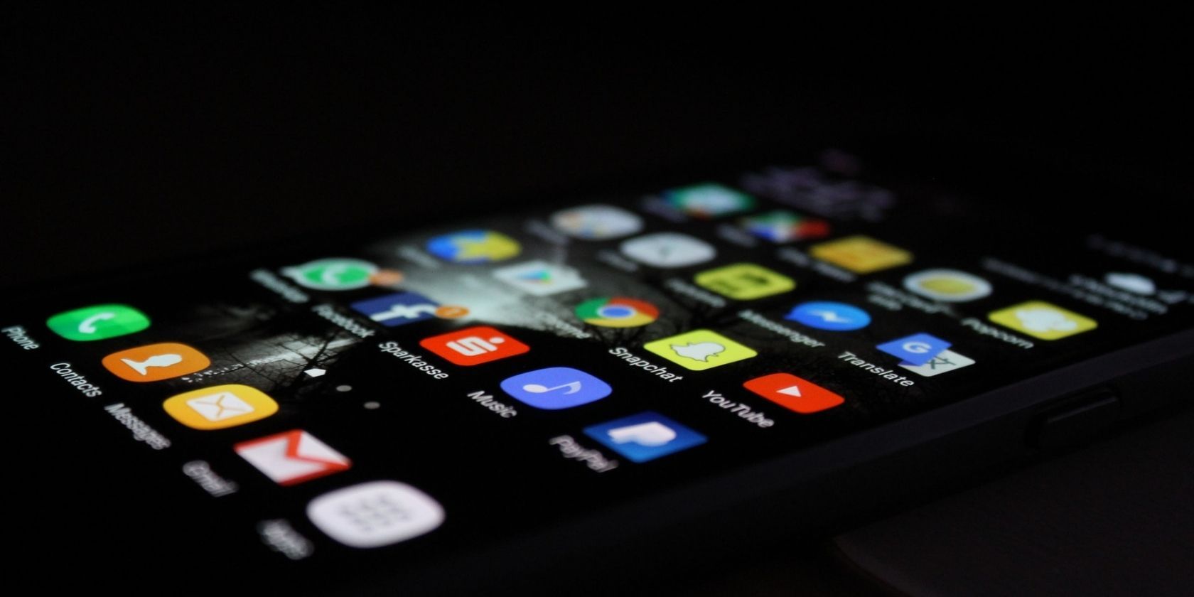upclose image of a black iPhone laying down with lit screen