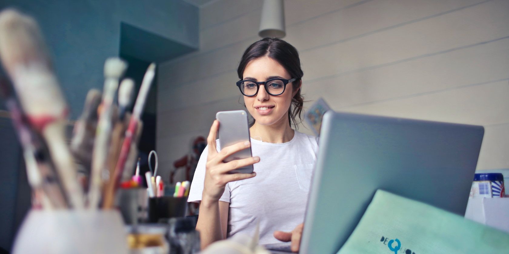 Woman smiling and holding smartphone in office environment