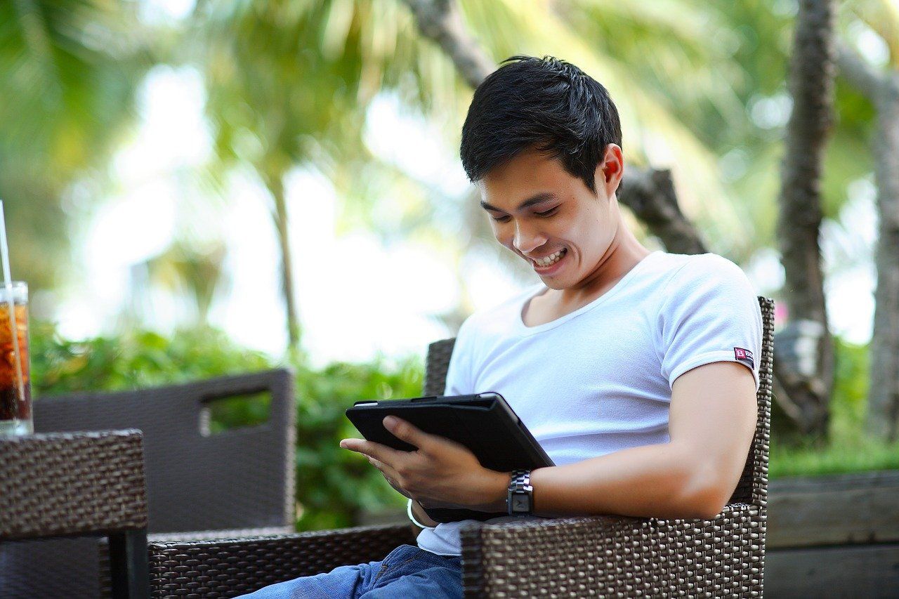 Young Man Smiling on Computer Device
