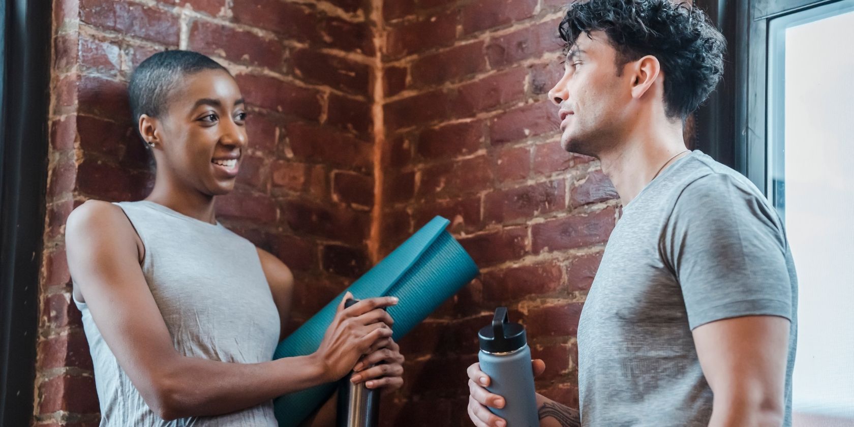 Cheerful diverse couple chatting in gym