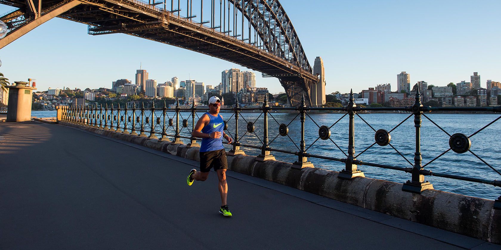 Photo of a runner with bridge in background