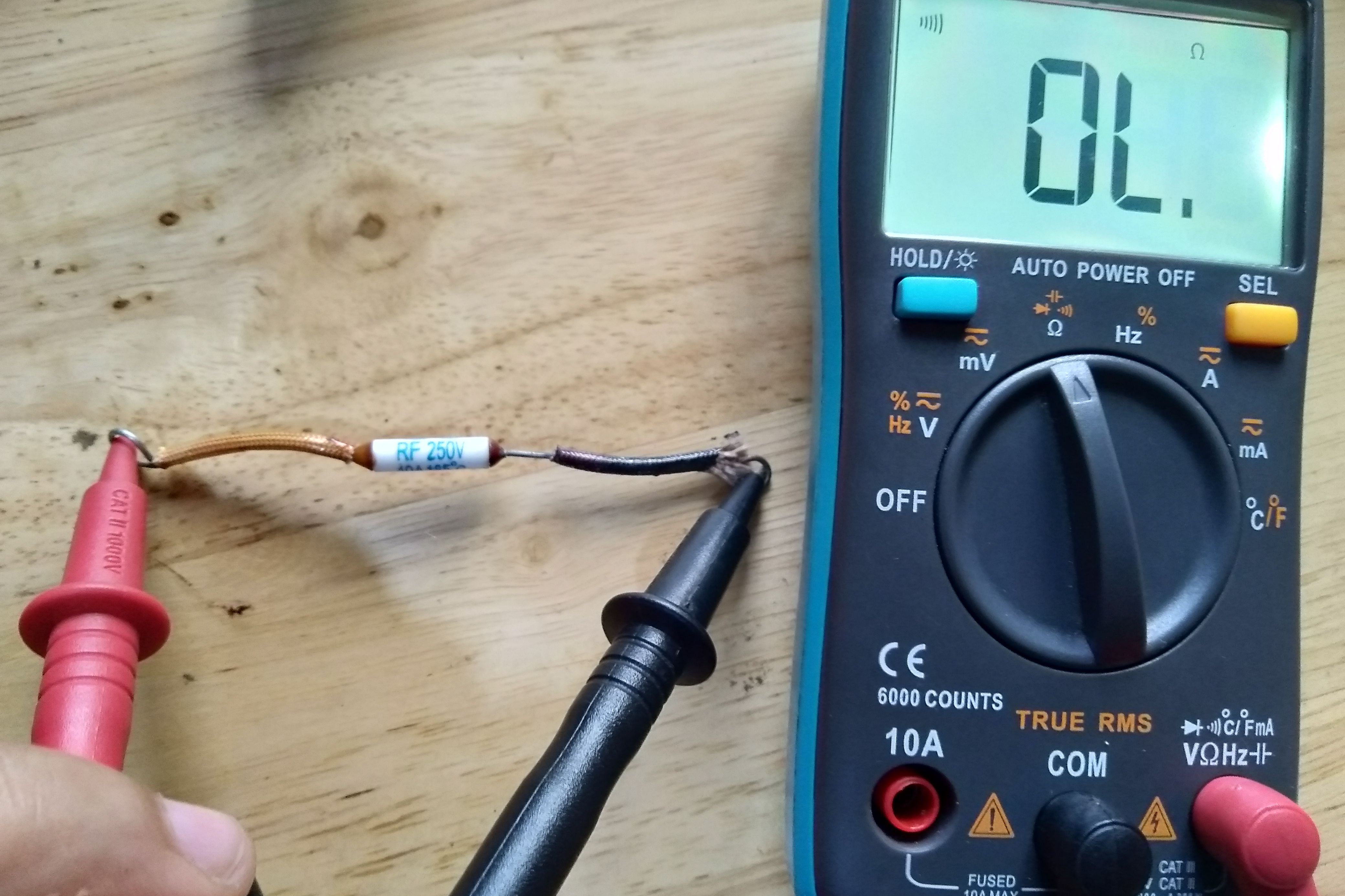 A multimeter testing the continuity of a fuse