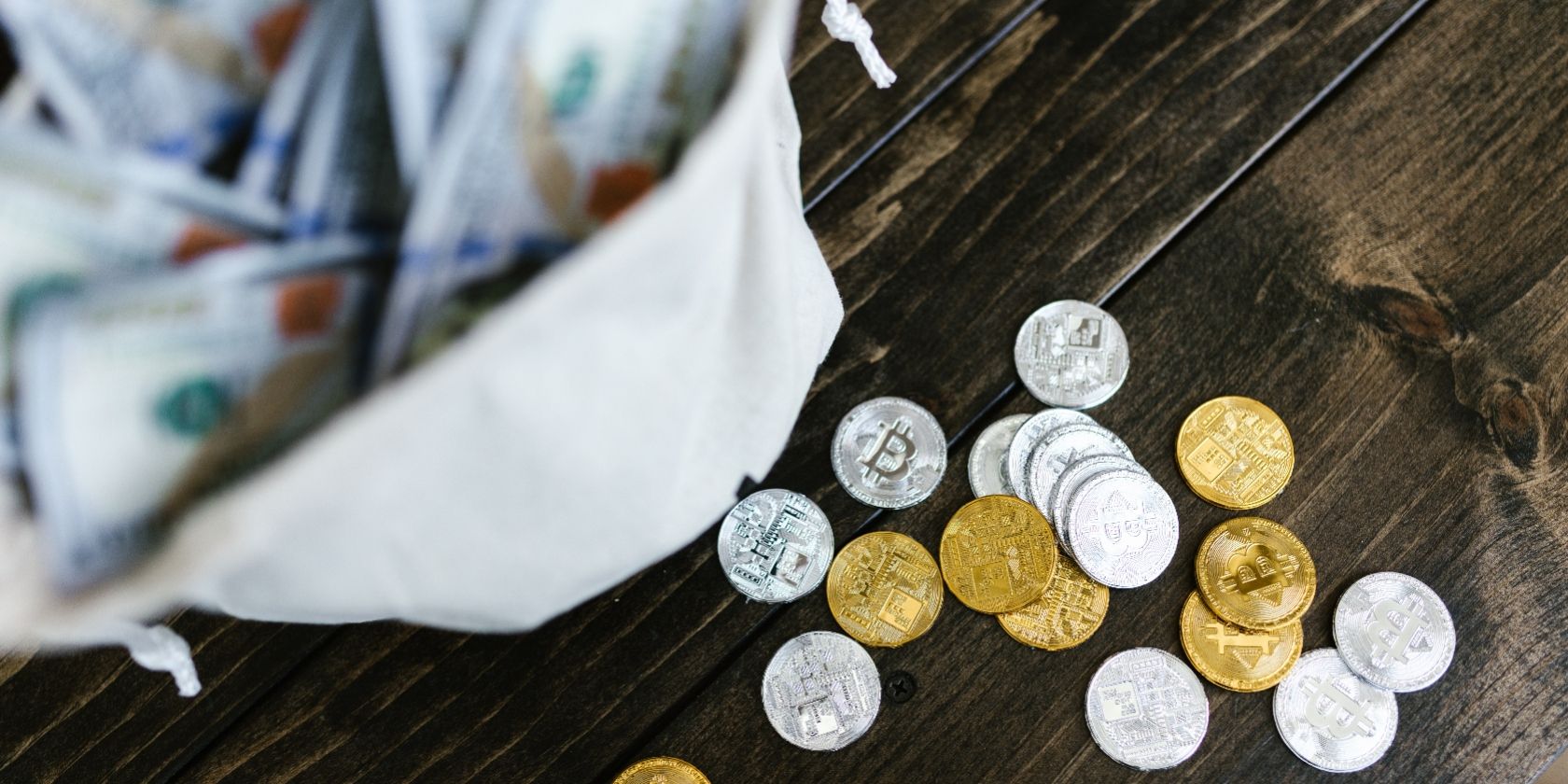bitcoins next to bag of money