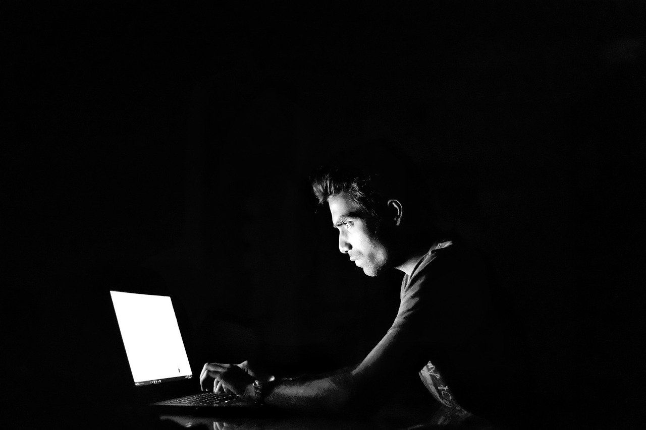 Cybercriminal on Computer in a Dark Room