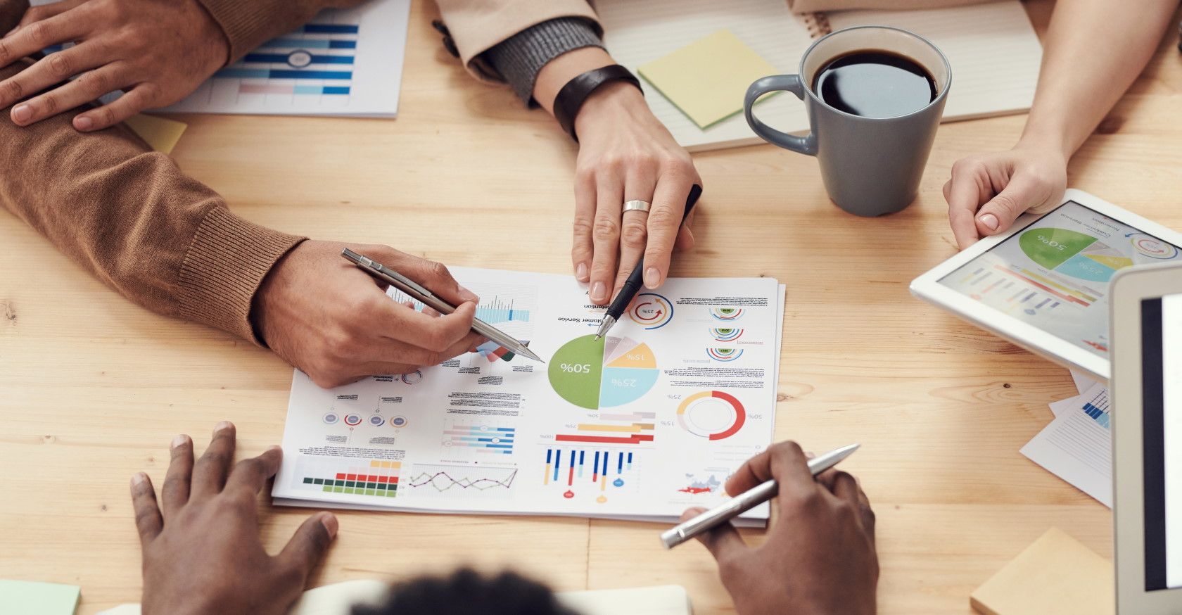 Employees sitting together at table discussing graphs and data