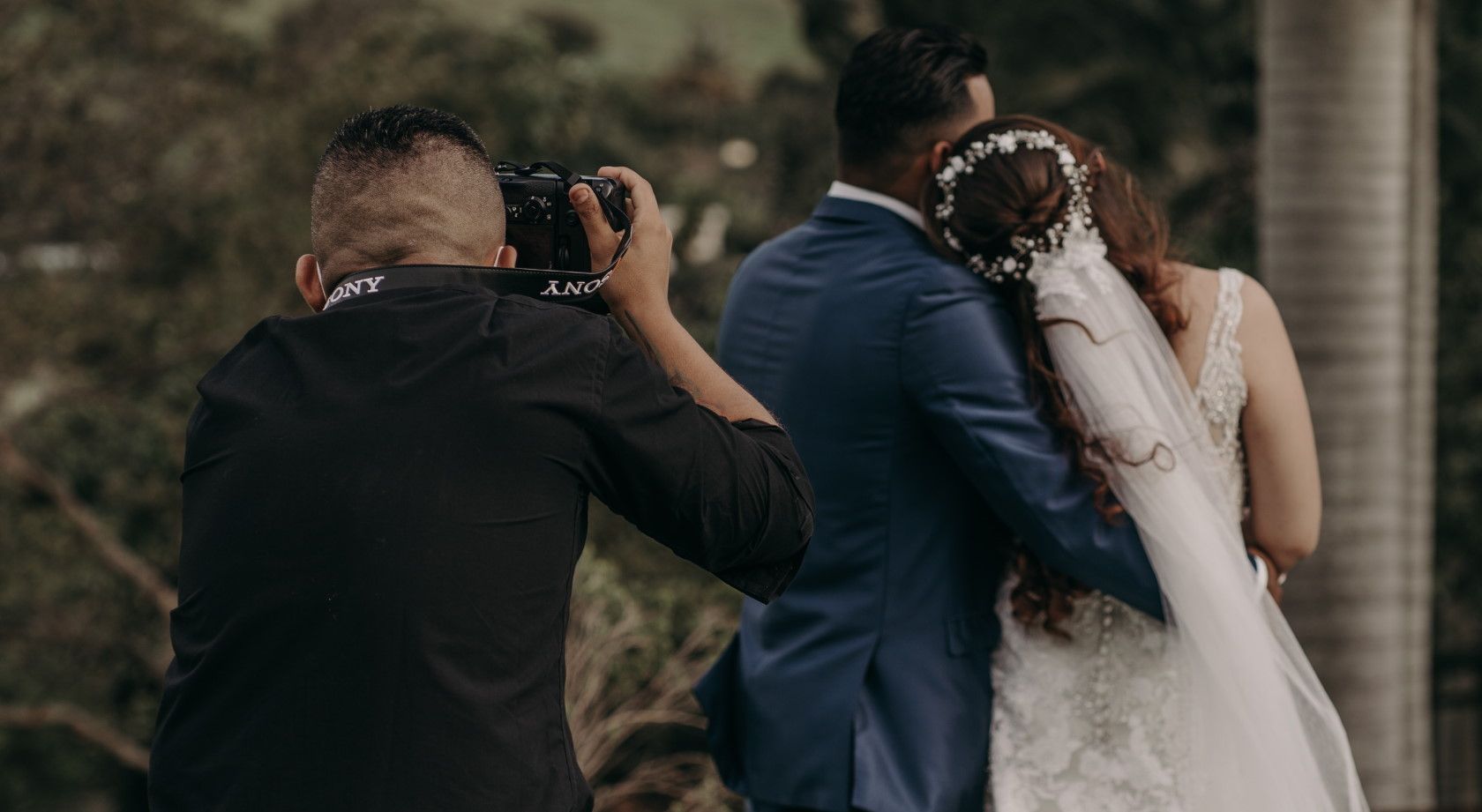 wedding photographer taking photographs of newlywed couple