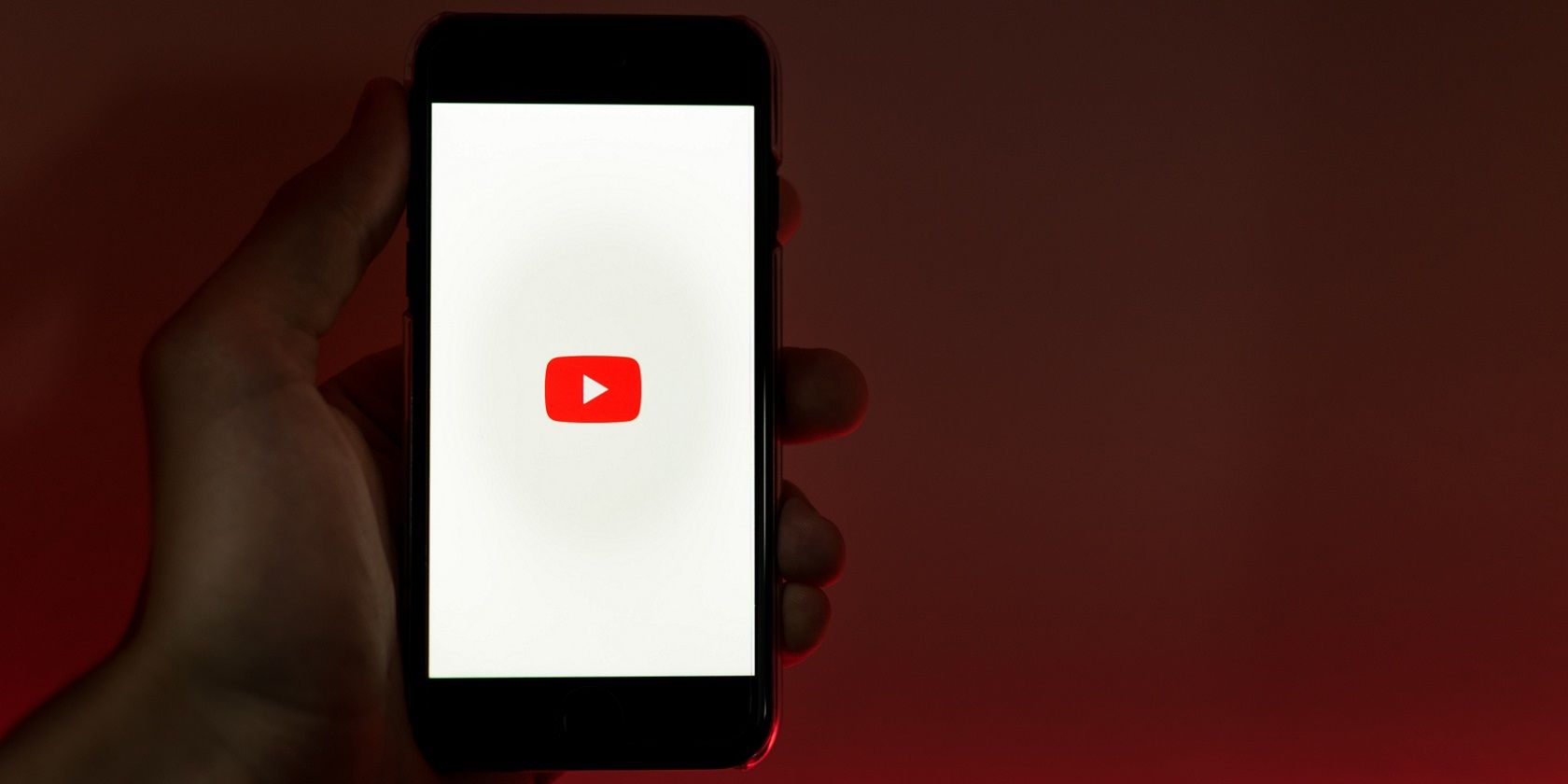hand holding phone with youtube logo on screen