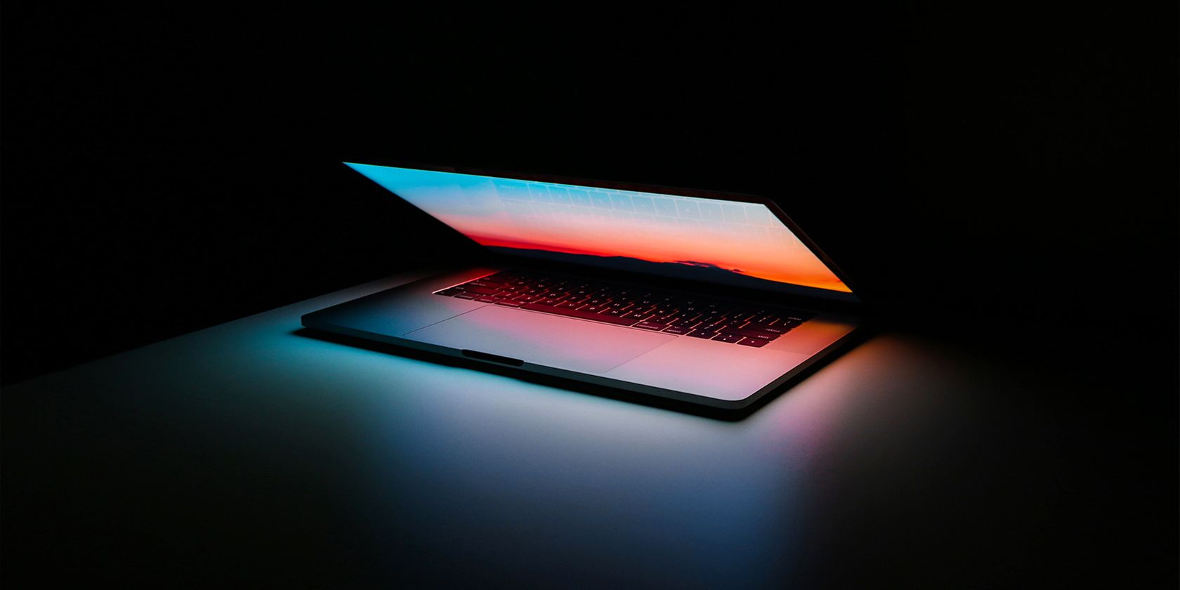 laptop on a desk in a dark room