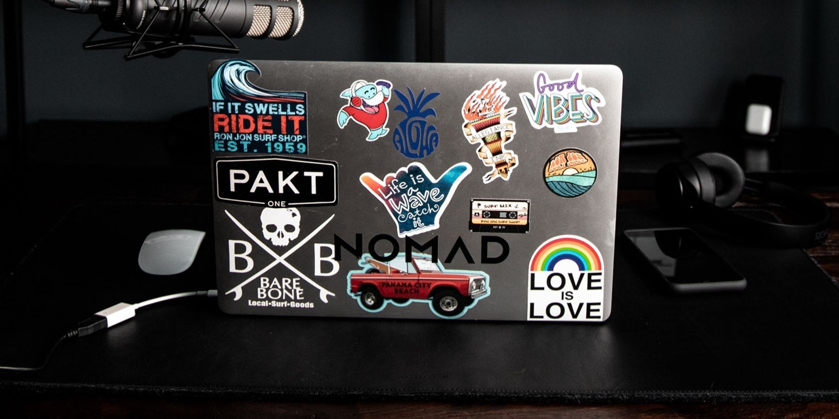 laptop on desk with multiple stickers on back