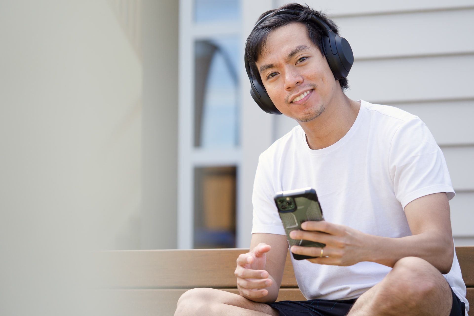 Man Using Earpiece on Mobile Phone Outside
