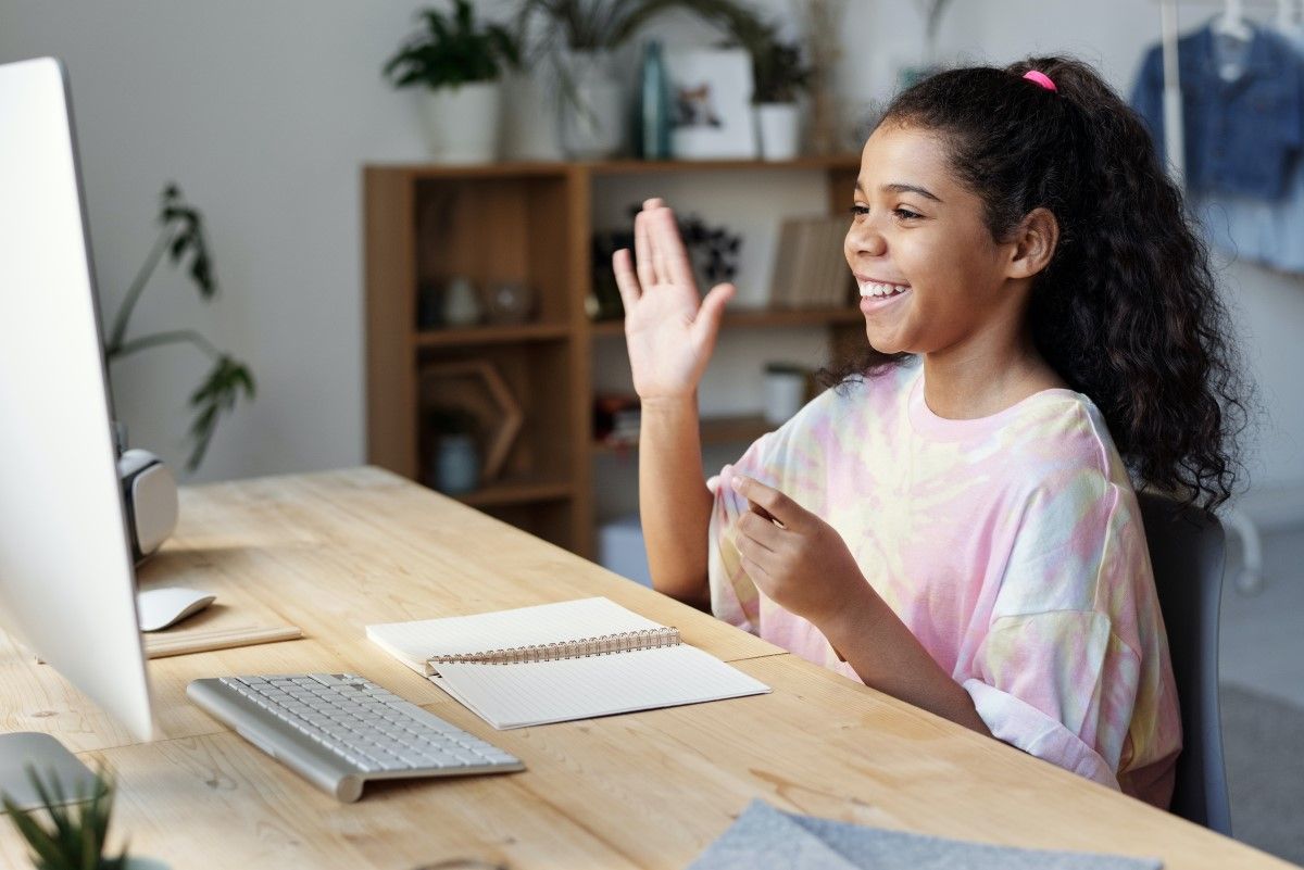 A Deaf girl communicates using ASL over her computer
