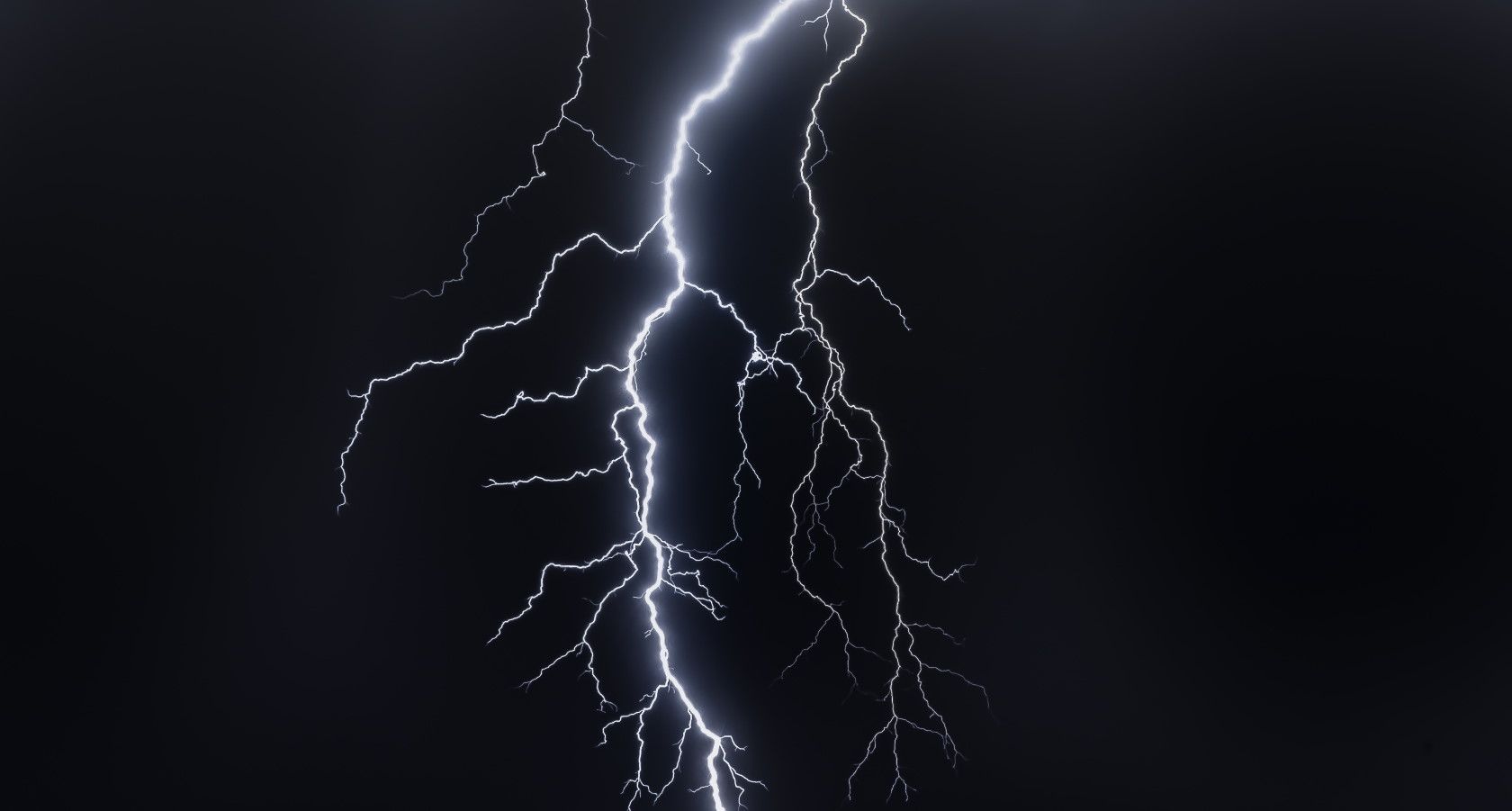 Lightning bolt striking in dark night sky