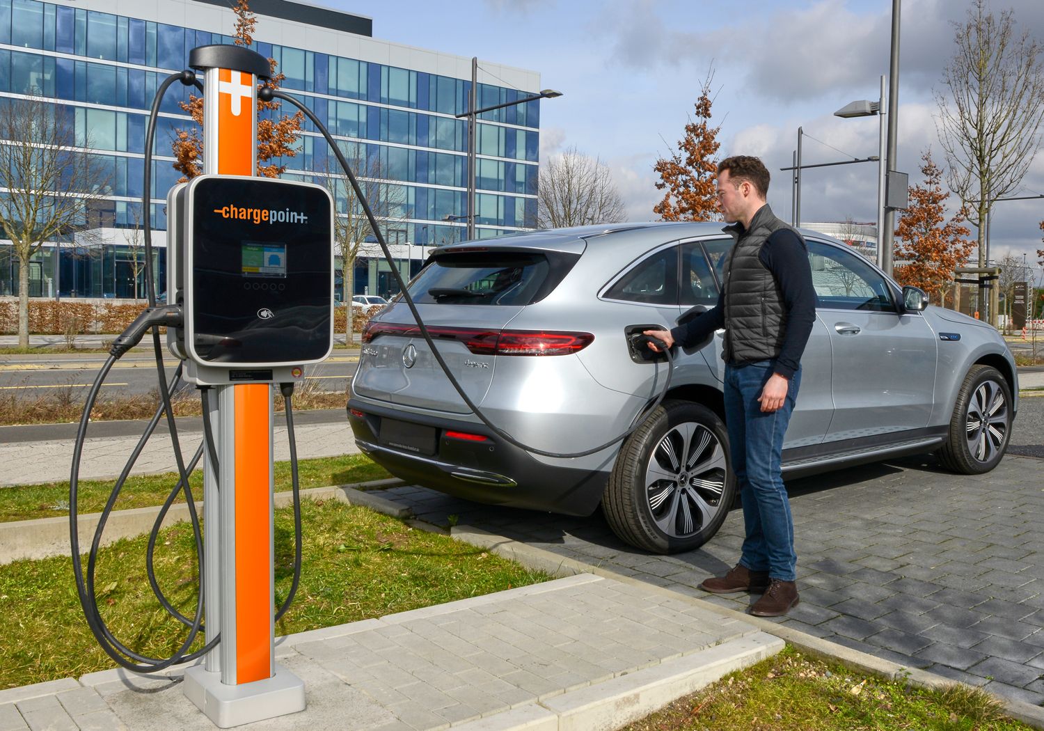 man charging electric car with orange chargepoint charger