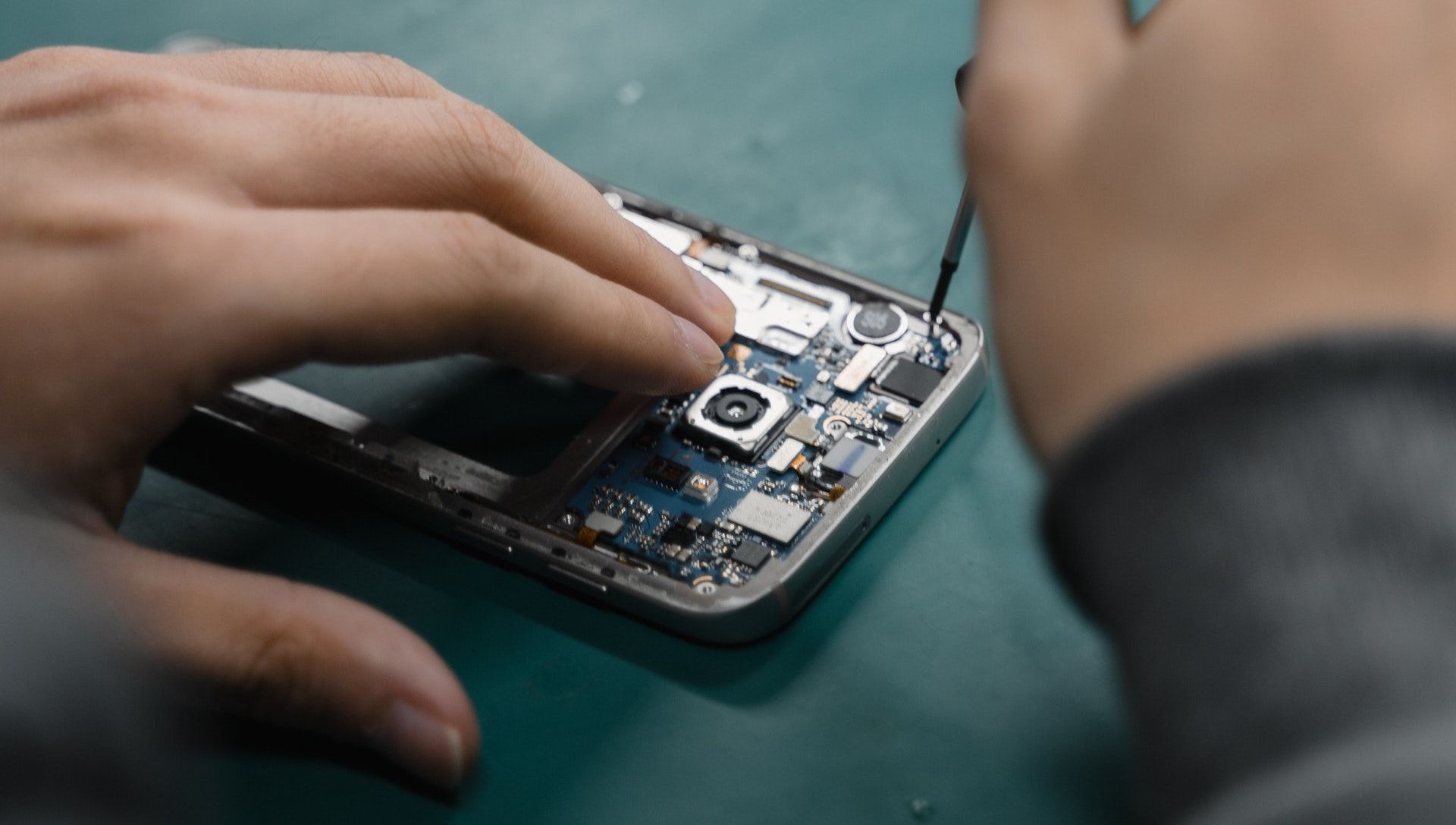 A close up shot of a samsung phone with exposed electronics being repaired