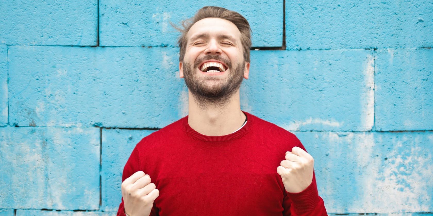 smiling man in red shirt