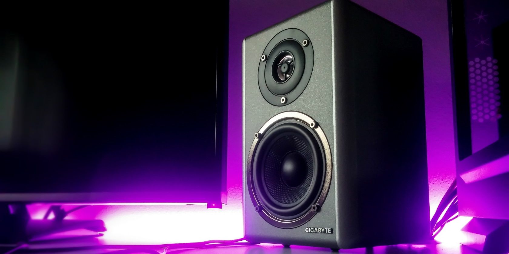 Close-up of black speakers in front of glowing purple backlight
