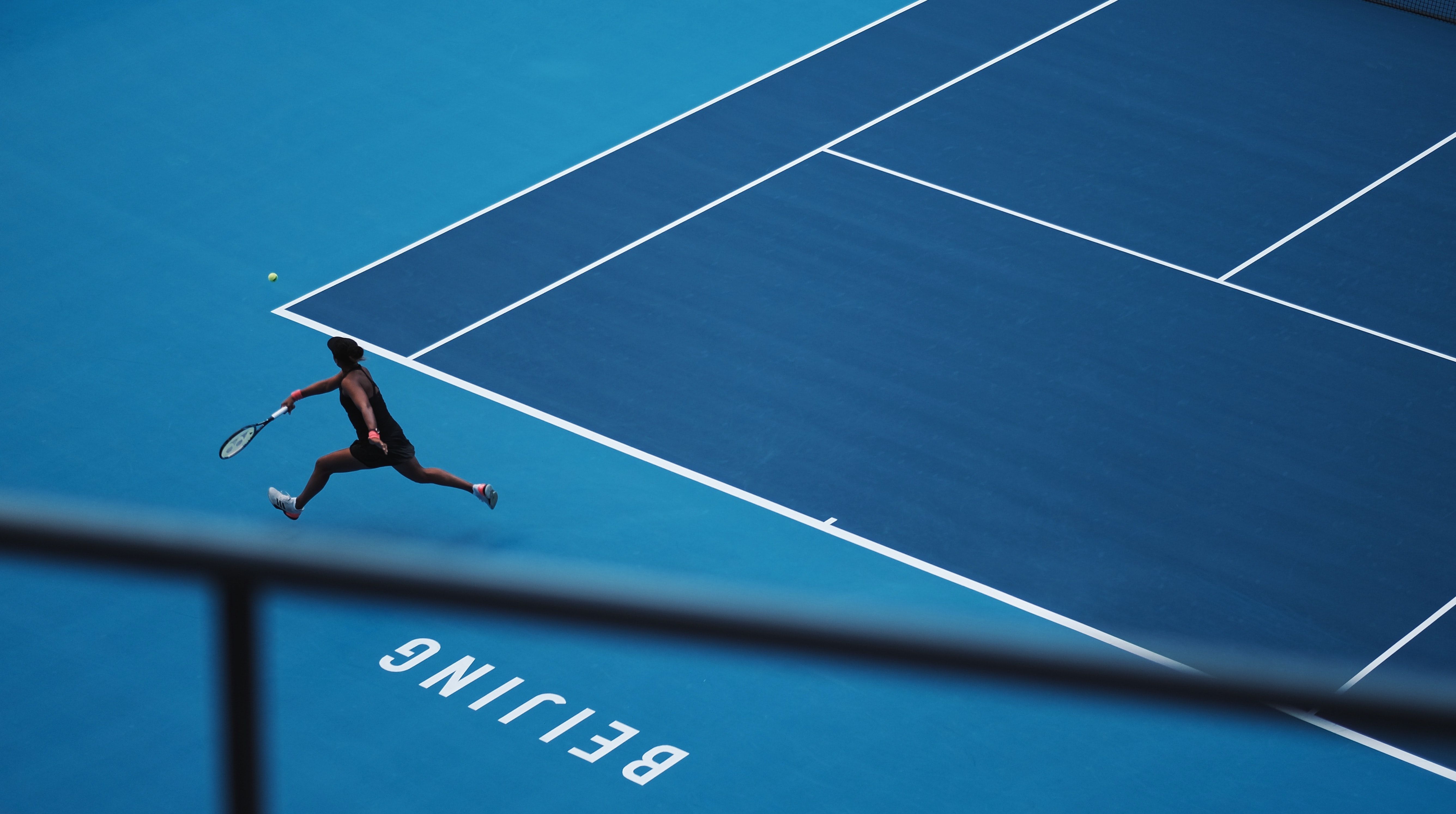 A tennis player on a blue court.