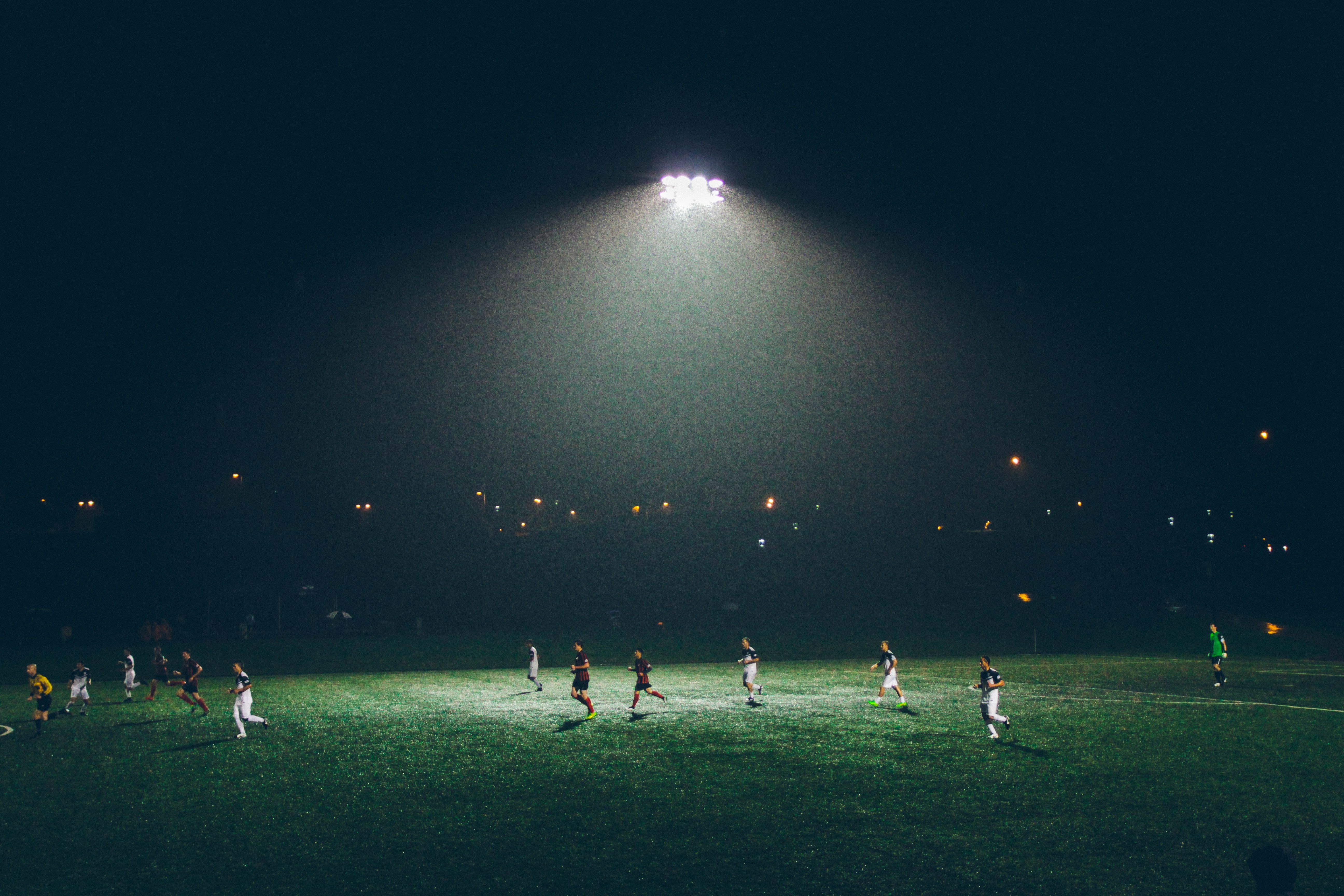 A bunch of soccer players at night.