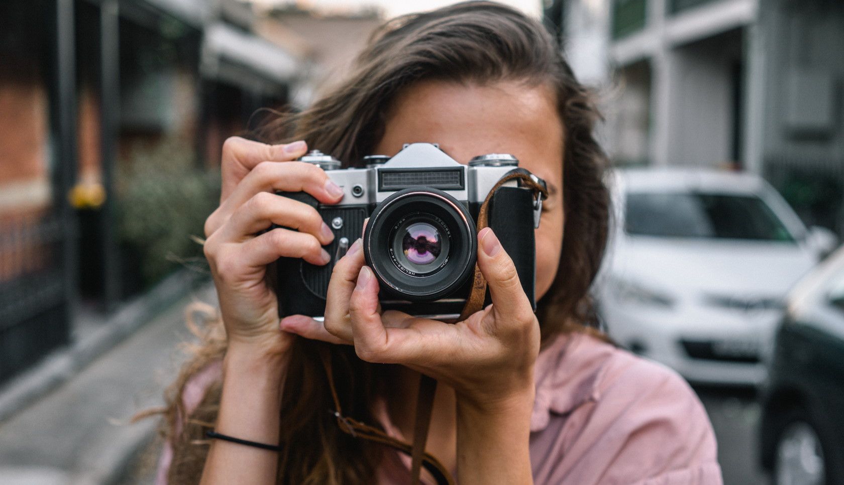 Front-facing shot of woman holding camera and focusing it