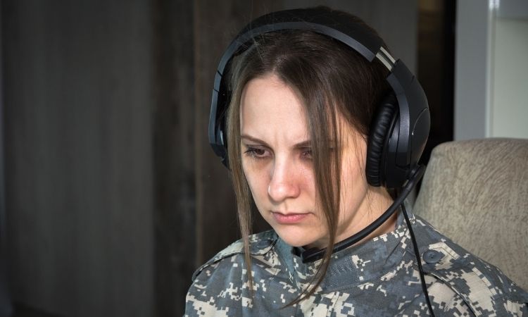 female soldier with a black headset on focusing intently