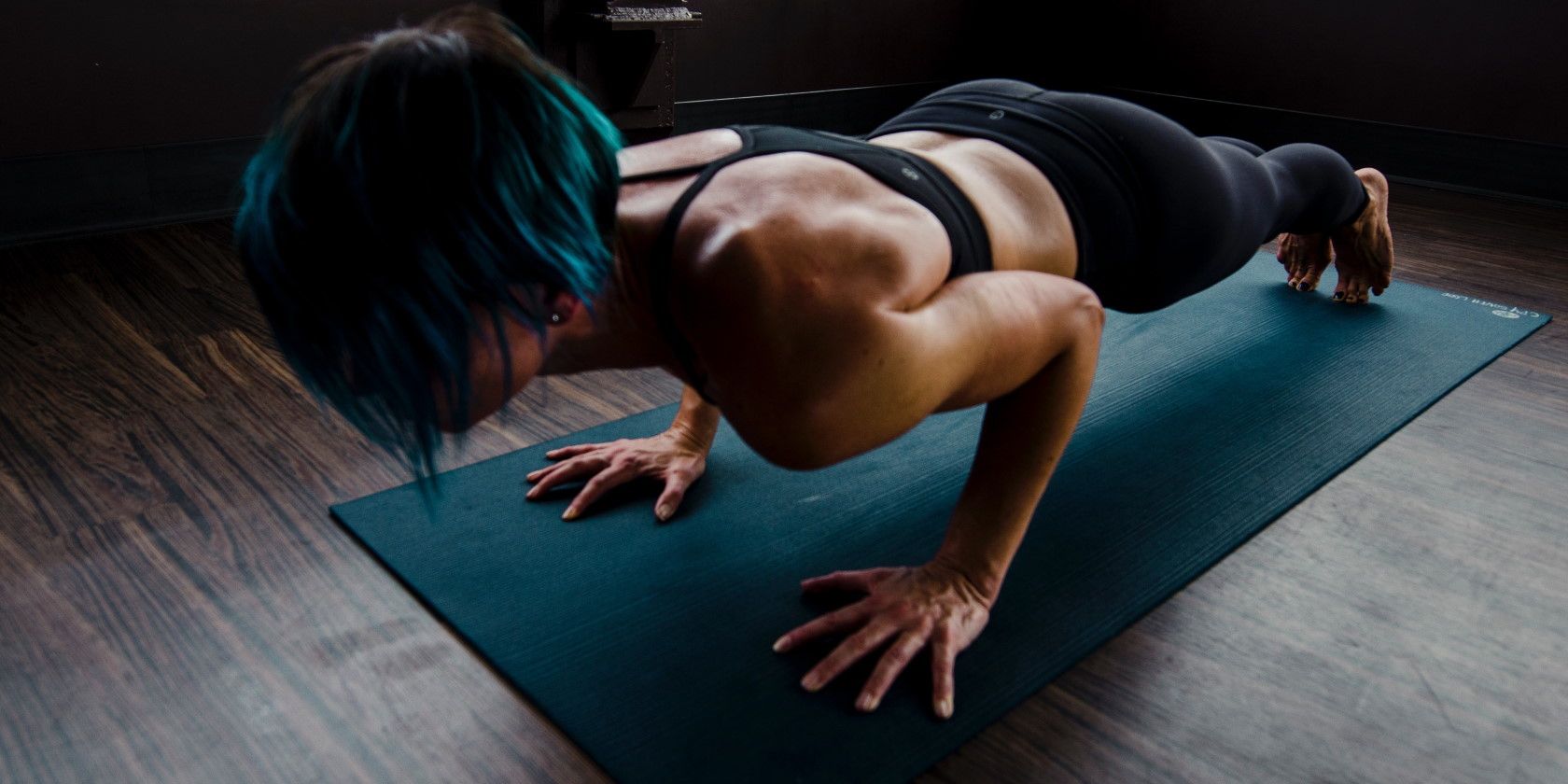 Woman leaning on exercise mat and doing push ups