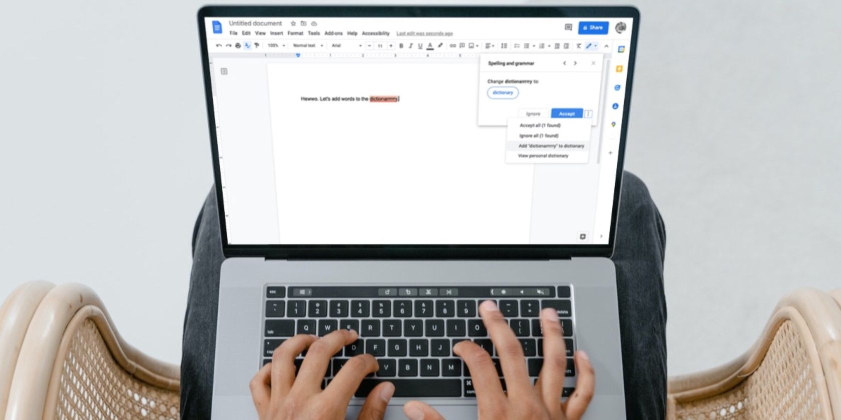 Image shows a man typing on a laptop using Google Docs 