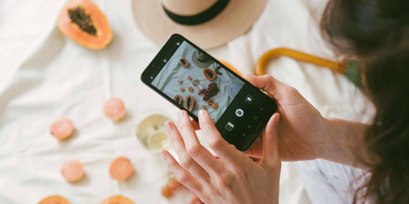 Женщина фотографирует фрукты на смартфоне
