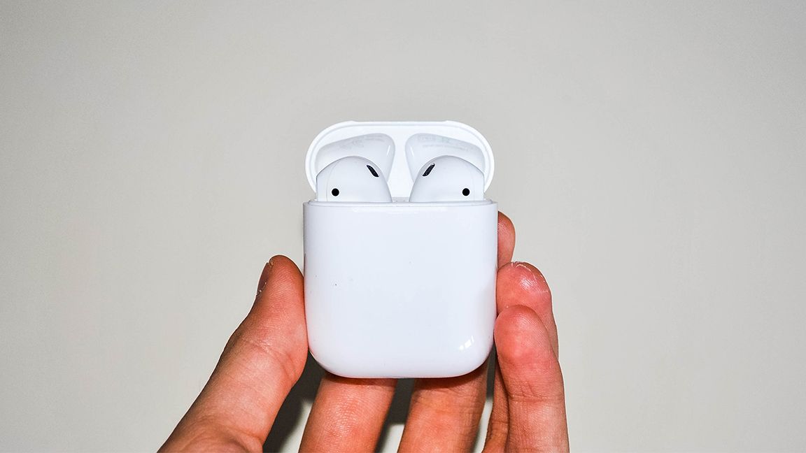 Holding AirPods and case in hand
