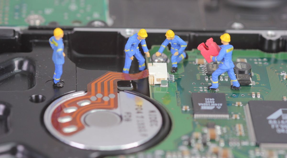 Miniature figures repairing a computer