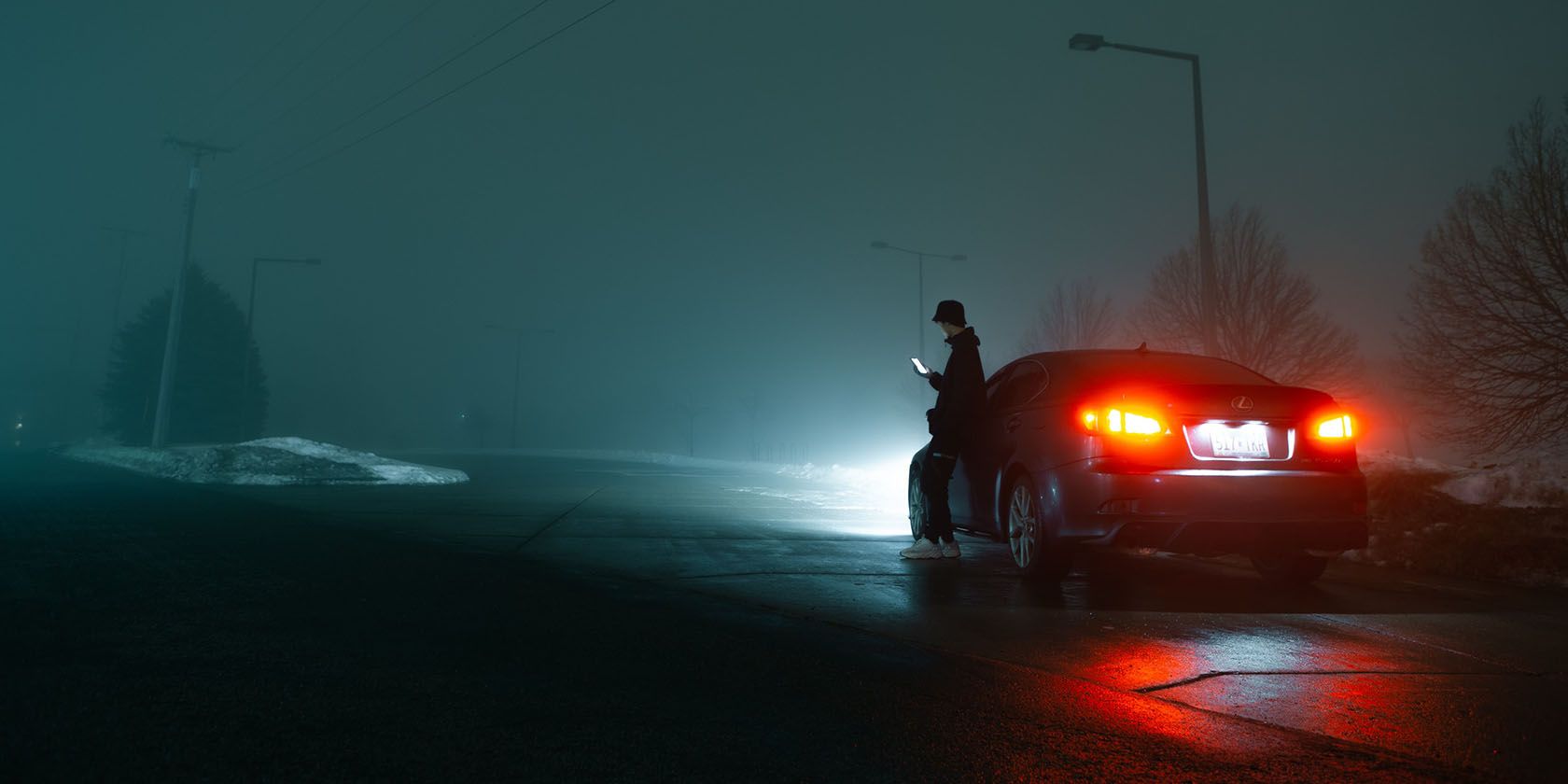 Person beside car at night