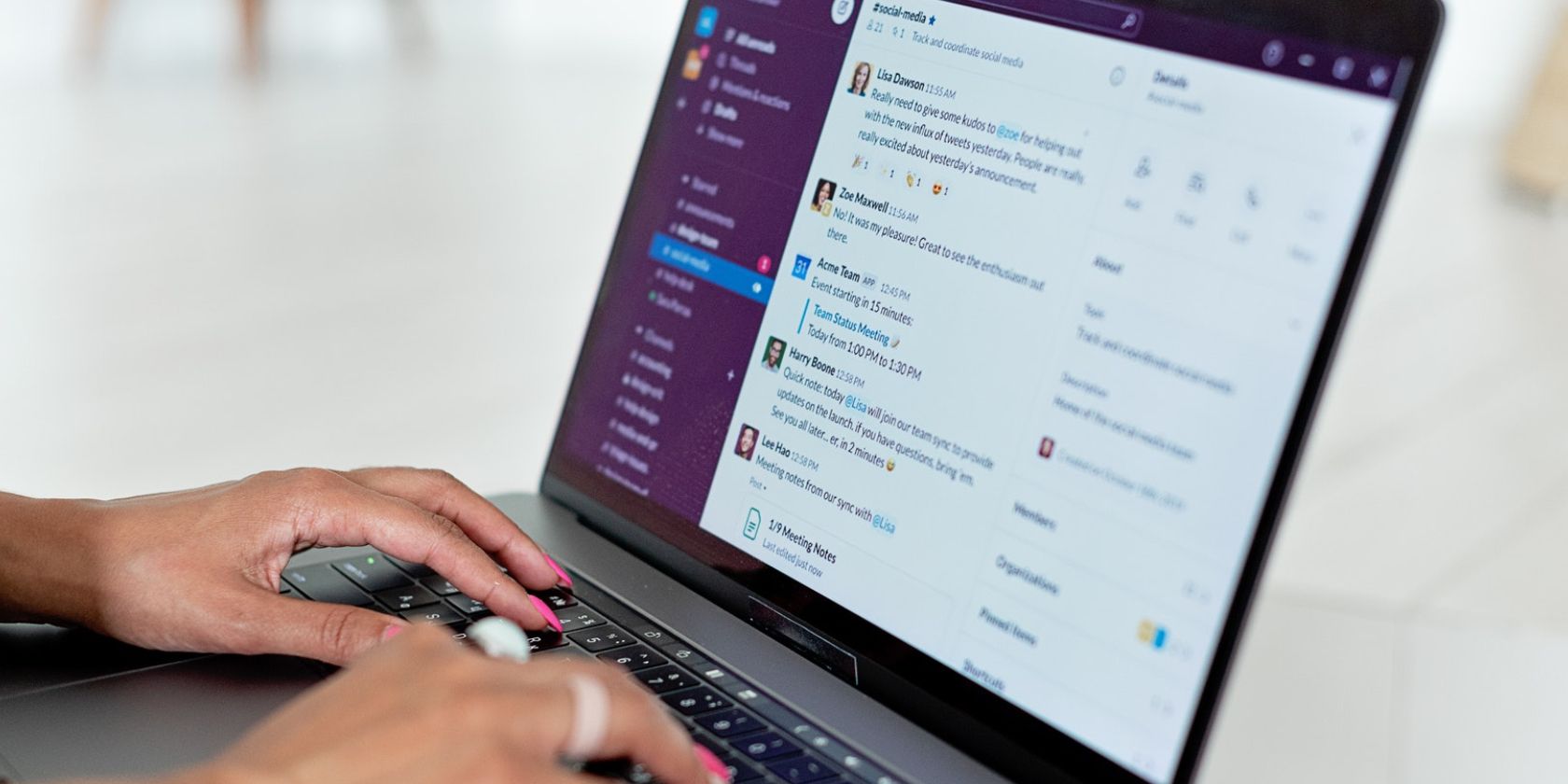 Image shows a woman using Slack on a laptop