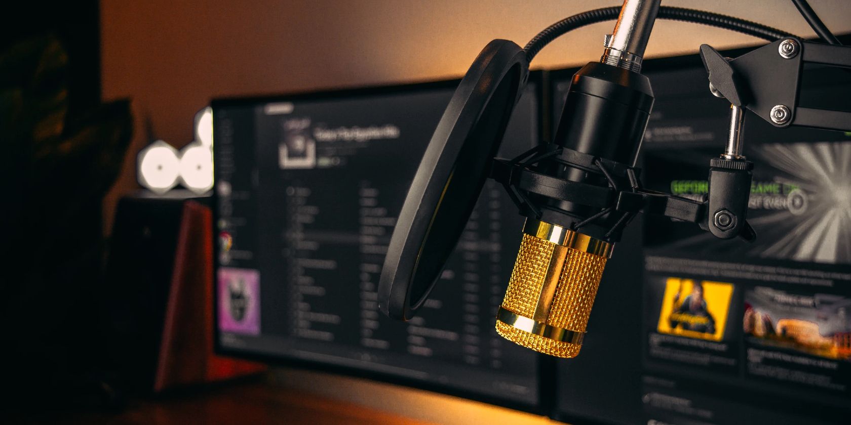 gold microphone with dual monitor with spotify in background