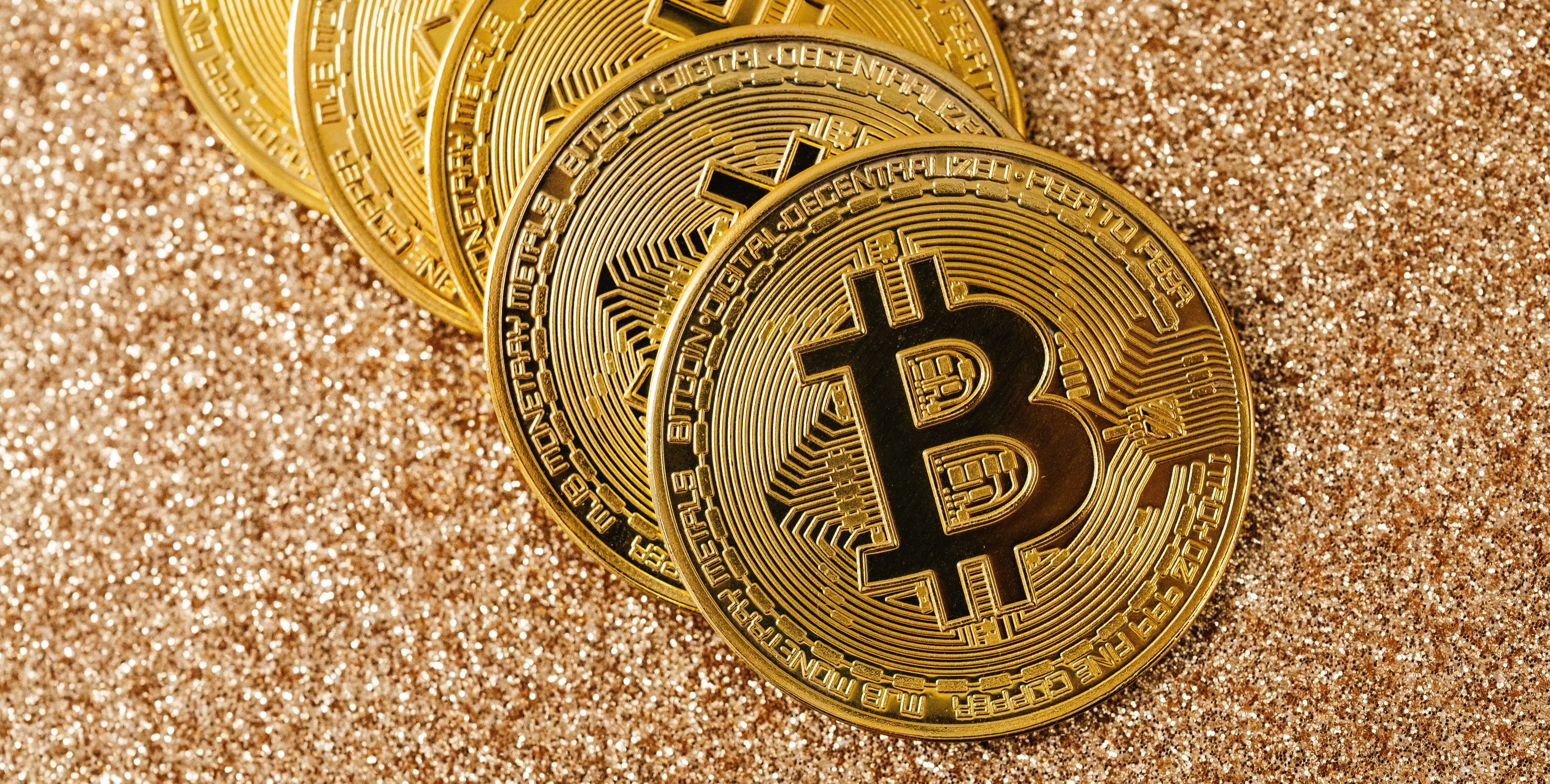gold bitcoin coins on gold glitter surface