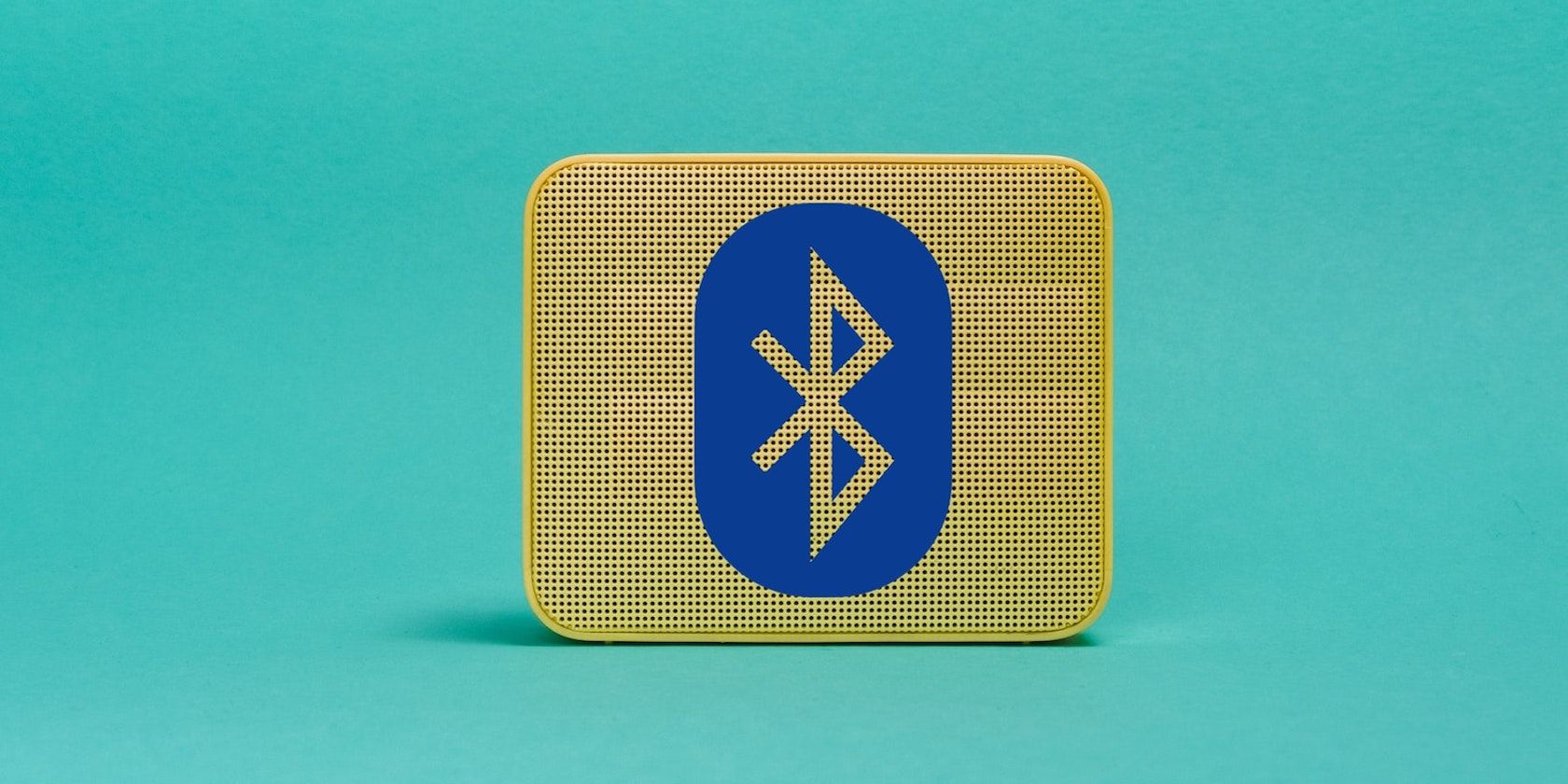 A bluetooth symbol on a yellow speaker in front of a bright turquoise background