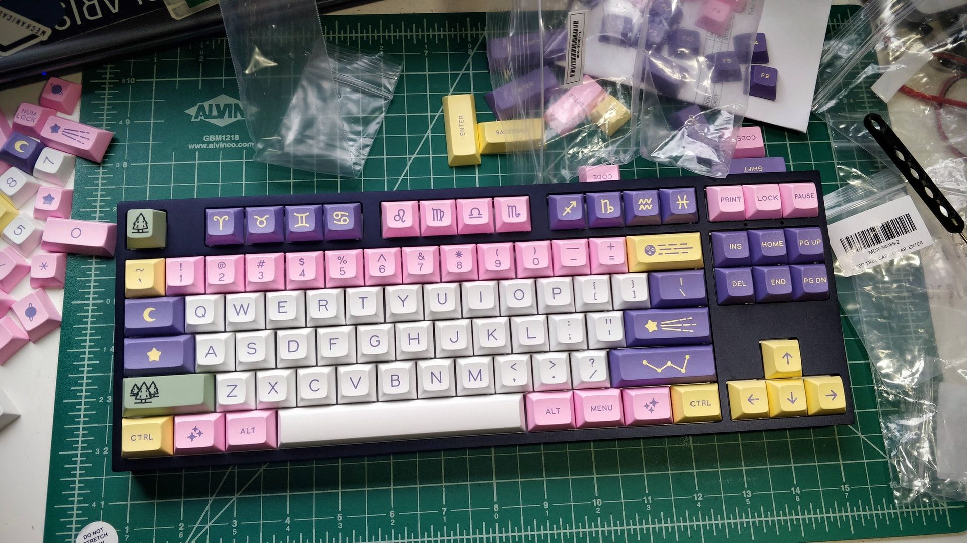 purple white pink yellow and green custom keycaps on desk mechanical keyboard