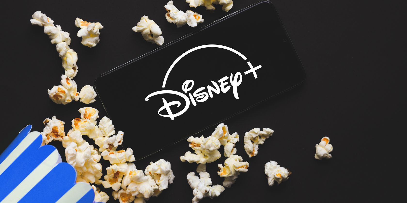 disney+ logo on phone surrounded by popcorn