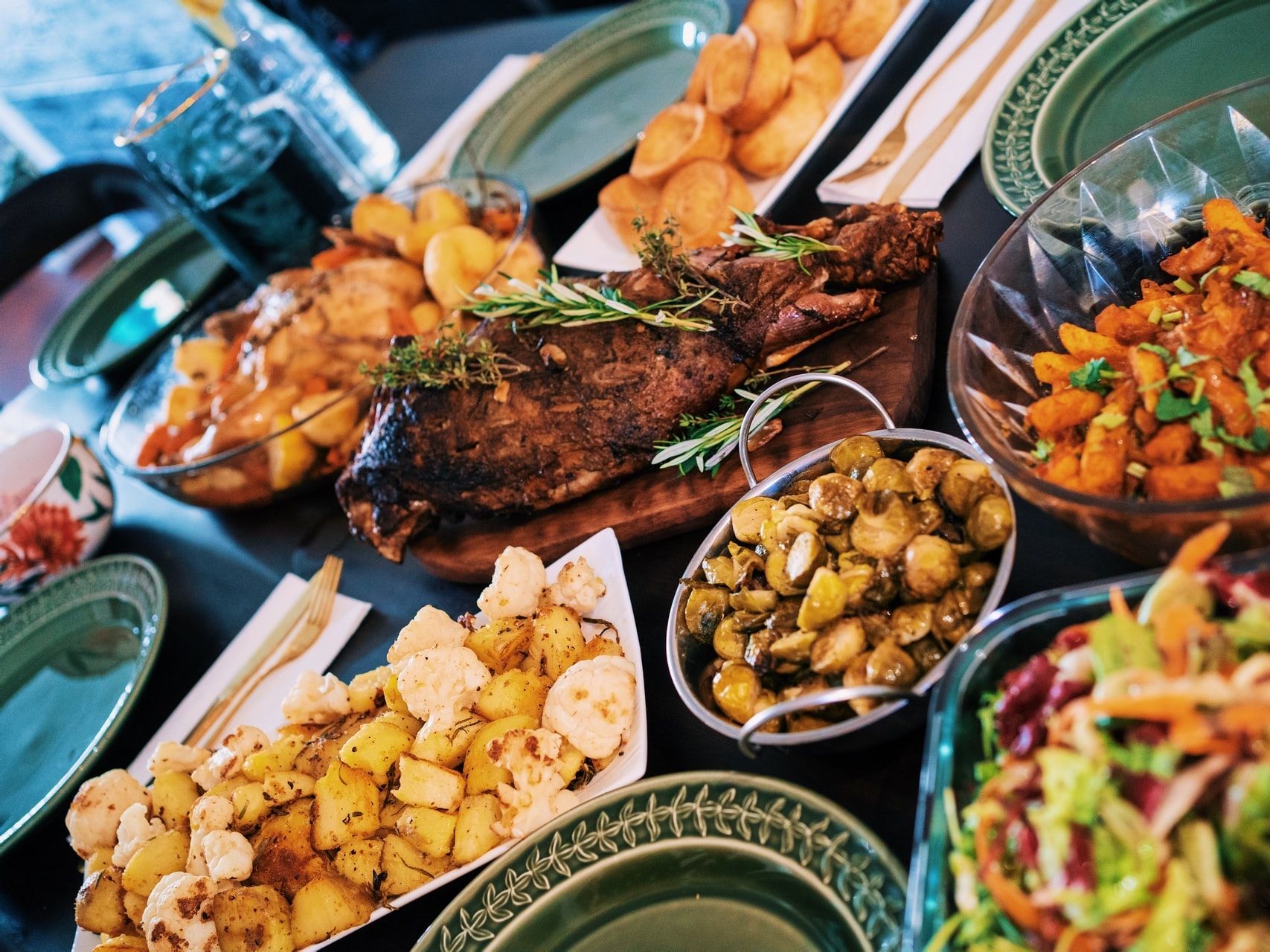 A photo tilted diagonally shows a table full of different food dishes