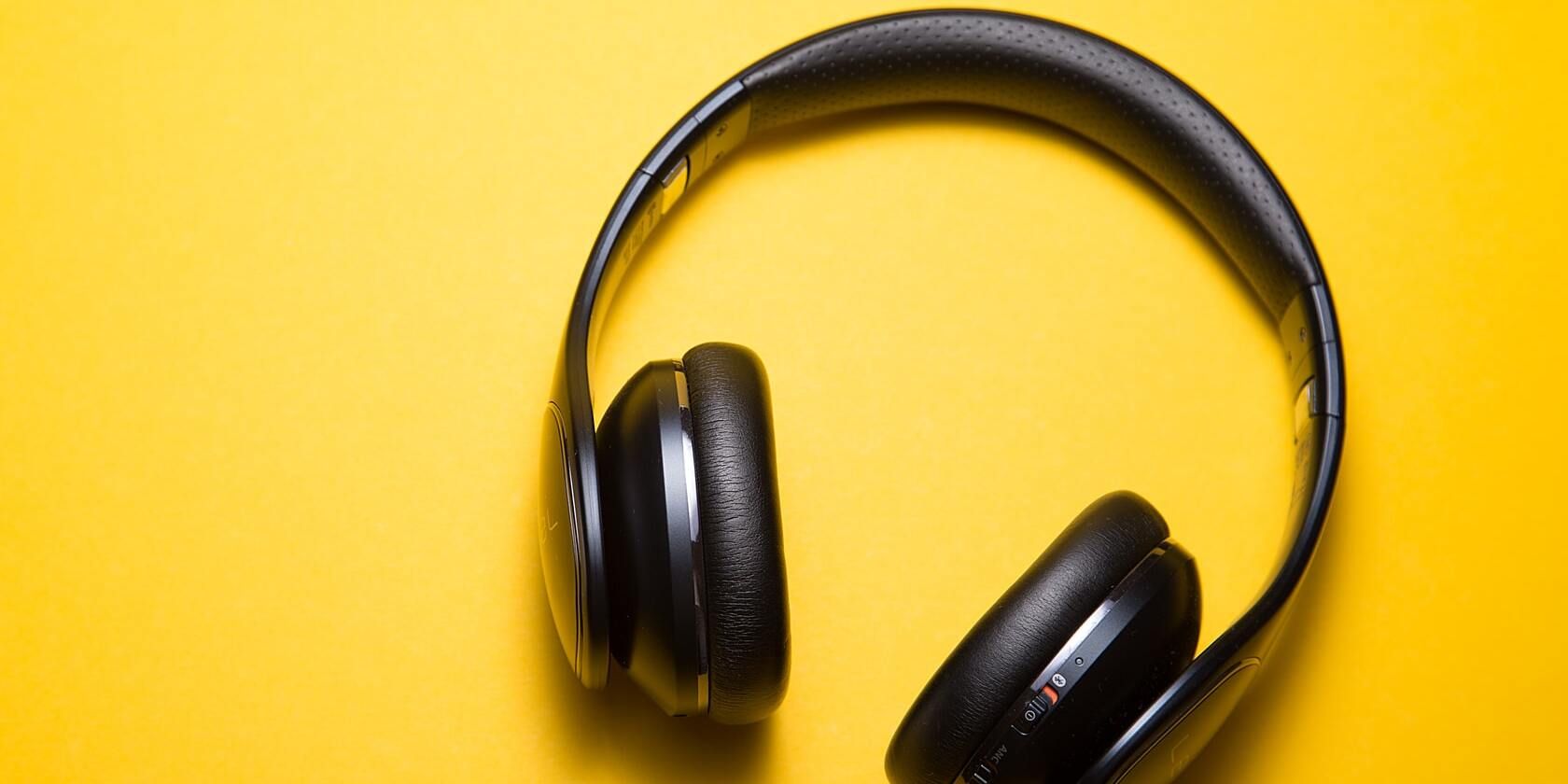 Wireless headphones on a yellow surface