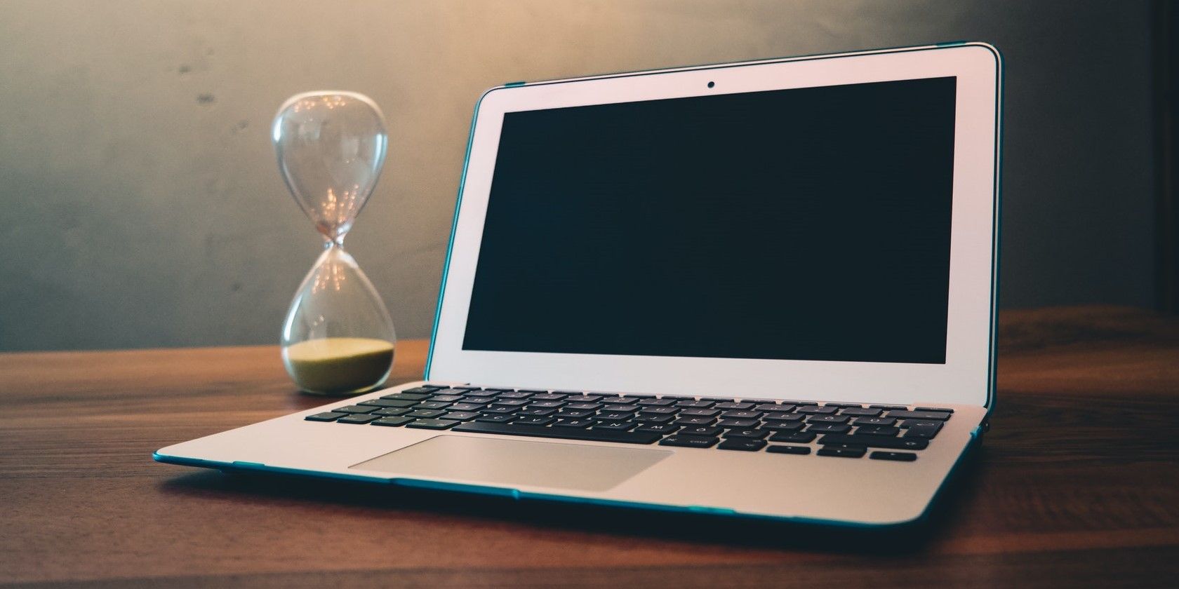 hourglass and laptop on a desk